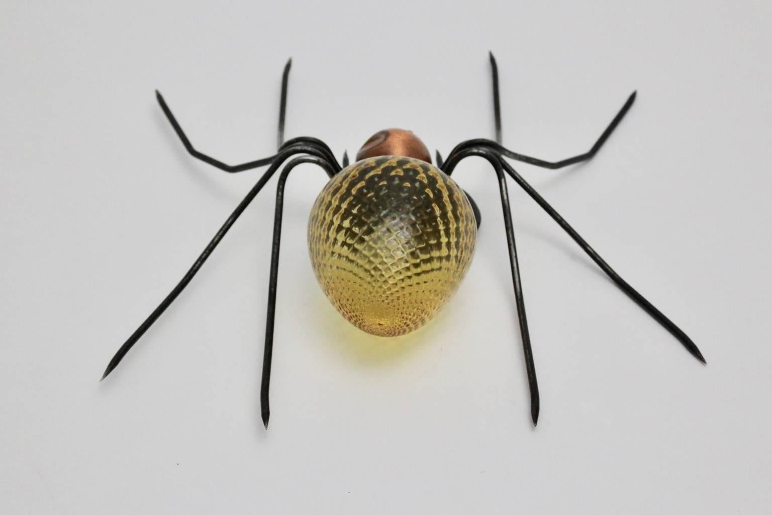 The extraordinary wall lamp is shaped like a spider. The legs were made of metal wire, while the body was made of yellow grooved glass and copper.
Inside the glass body is a E 14 socket.
This lighting works perfect as well as table lamp or