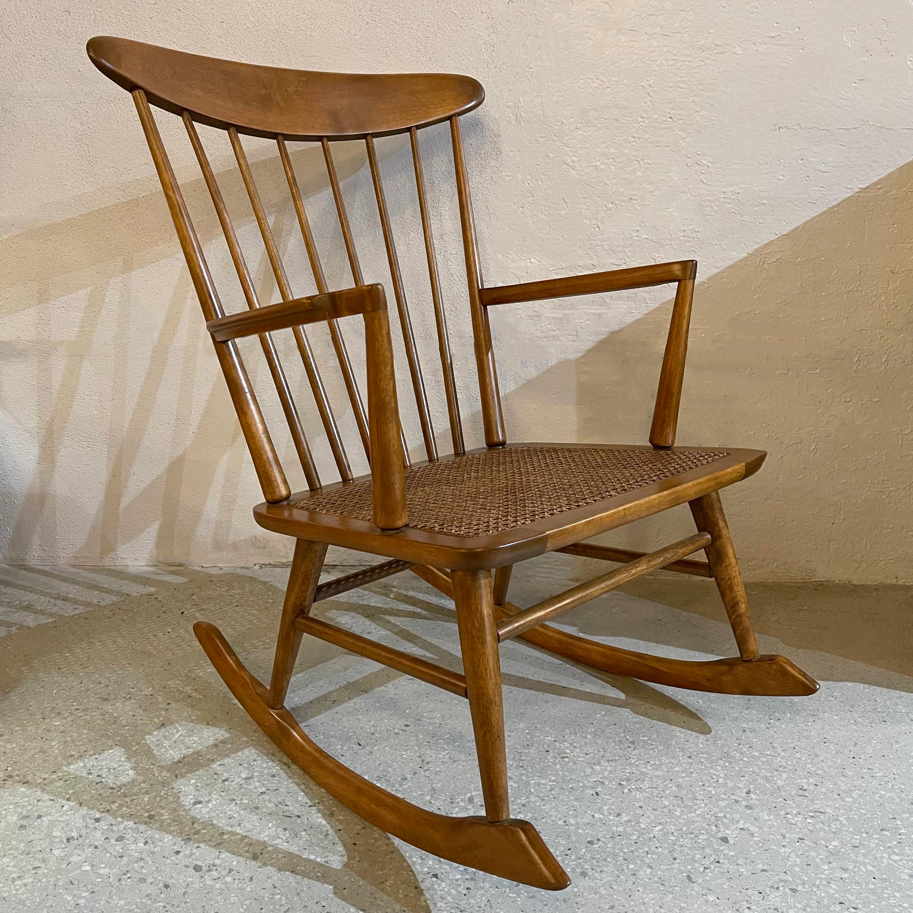 Mid-century modern, beech wood, rocking chair features a high spindle back with newly caned seat. The chair is American but has a Scandinavian feel with it's sculpted frame and tapered spindles. Arm height is 24 inches.
