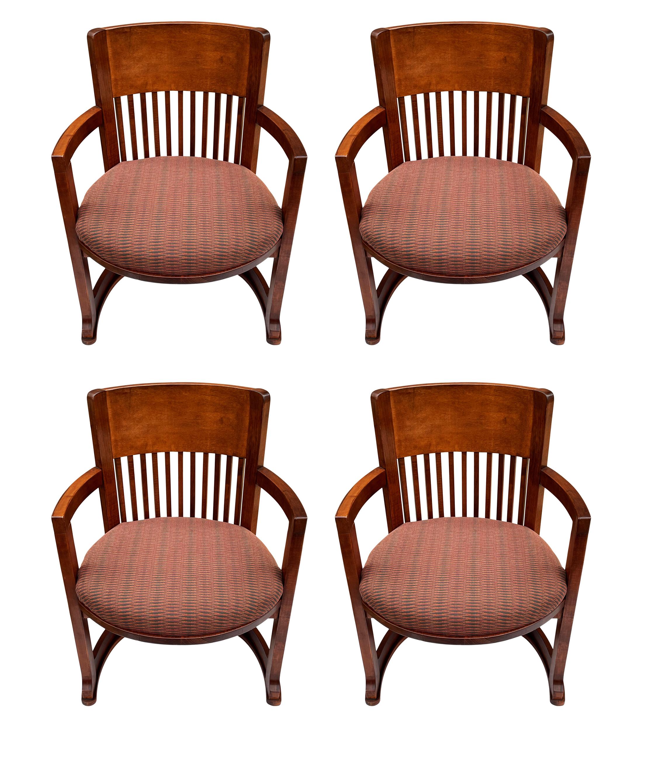 A complete set of four barrel back chairs after Frank Lloyd Wright. These feature solid wood construction with upholstered seat pads. Price includes set of four.