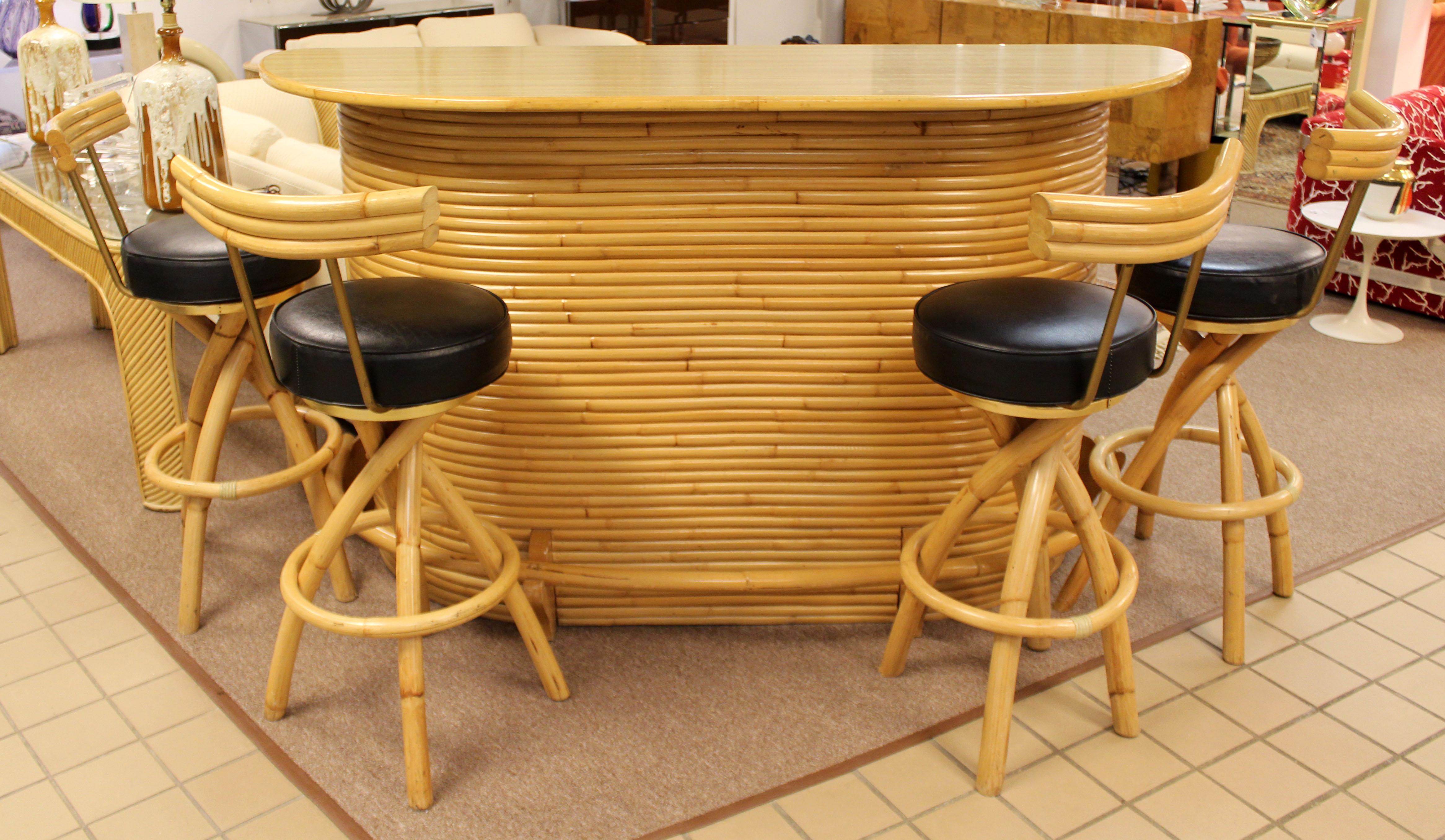 For your consideration is a fantastic, curved split reed bamboo bar, with a set of four matching arched rattan bar stools, with black leather padded swivel seats. In very good vintage condition. The dimensions of the bar are 72.5