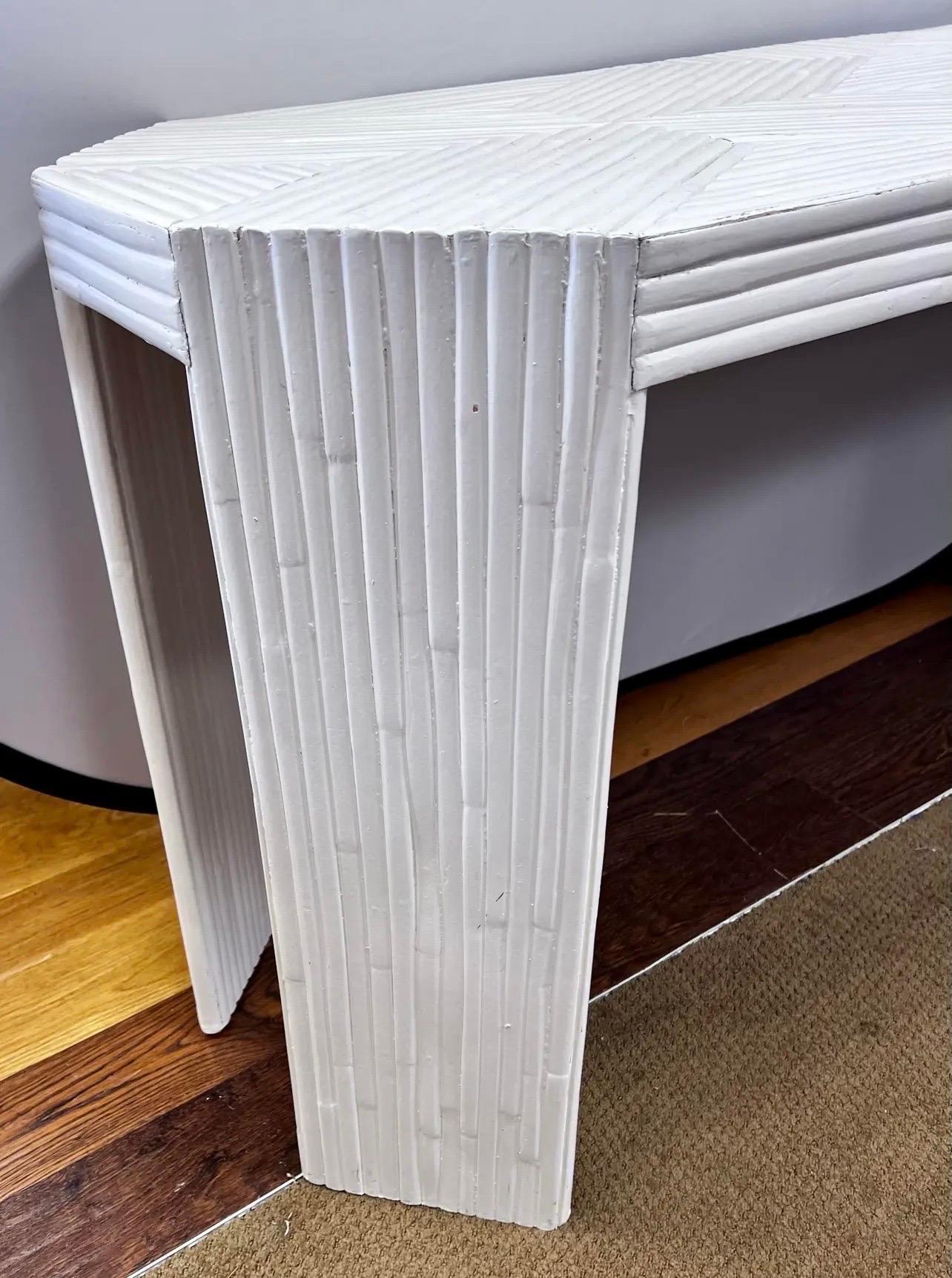 Mid Century split bamboo console table.  Individual bamboo pieces diagonally applied in sections at the tabletop creating a dramatic X
effect in a painted white finish.