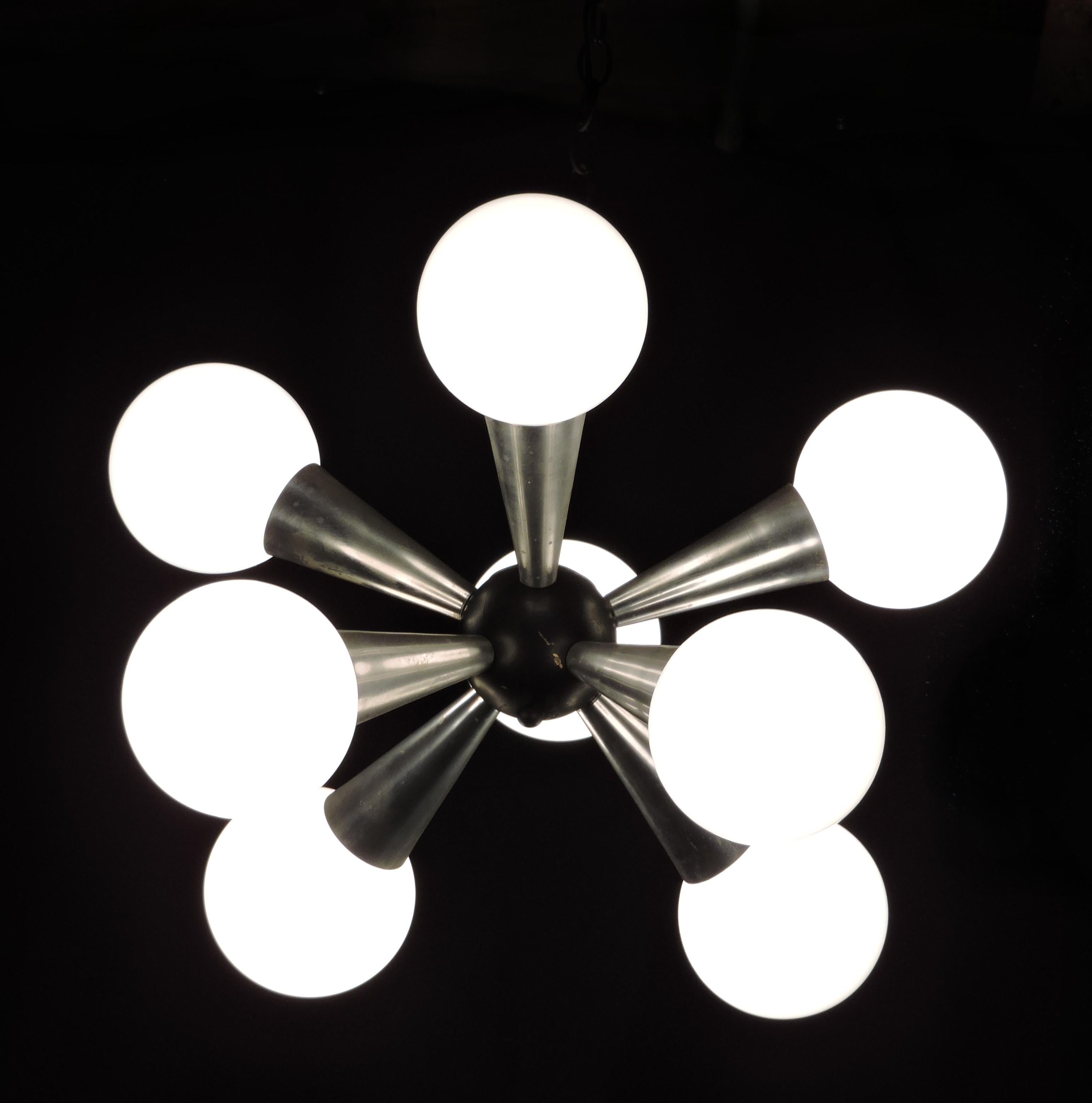 Très cool lustre Sputnik à 8 lumières. Ce luminaire comporte 8 bras en forme de cône en aluminium qui rayonnent à partir d'une boule centrale noire. Il y a une chaîne de 18 pouces, ce qui donne une chute d'environ 31 pouces jusqu'au bas du
