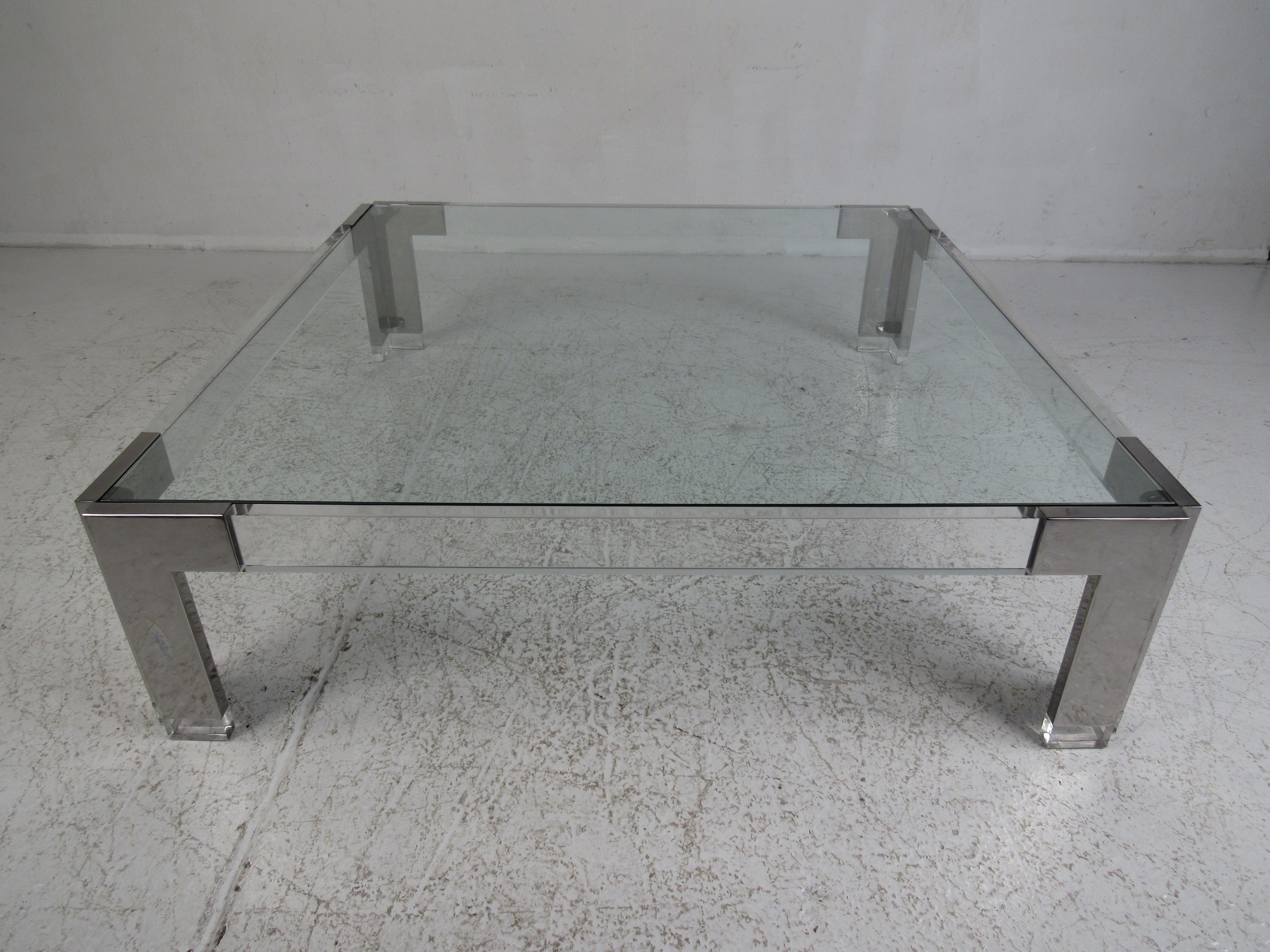 An elegant vintage modern coffee table with a Lucite and chrome base. The impressive two-tone design adds style and grace to any modern interior. A large square glass top rests comfortably on top of the sturdy base ensuring plenty of space for