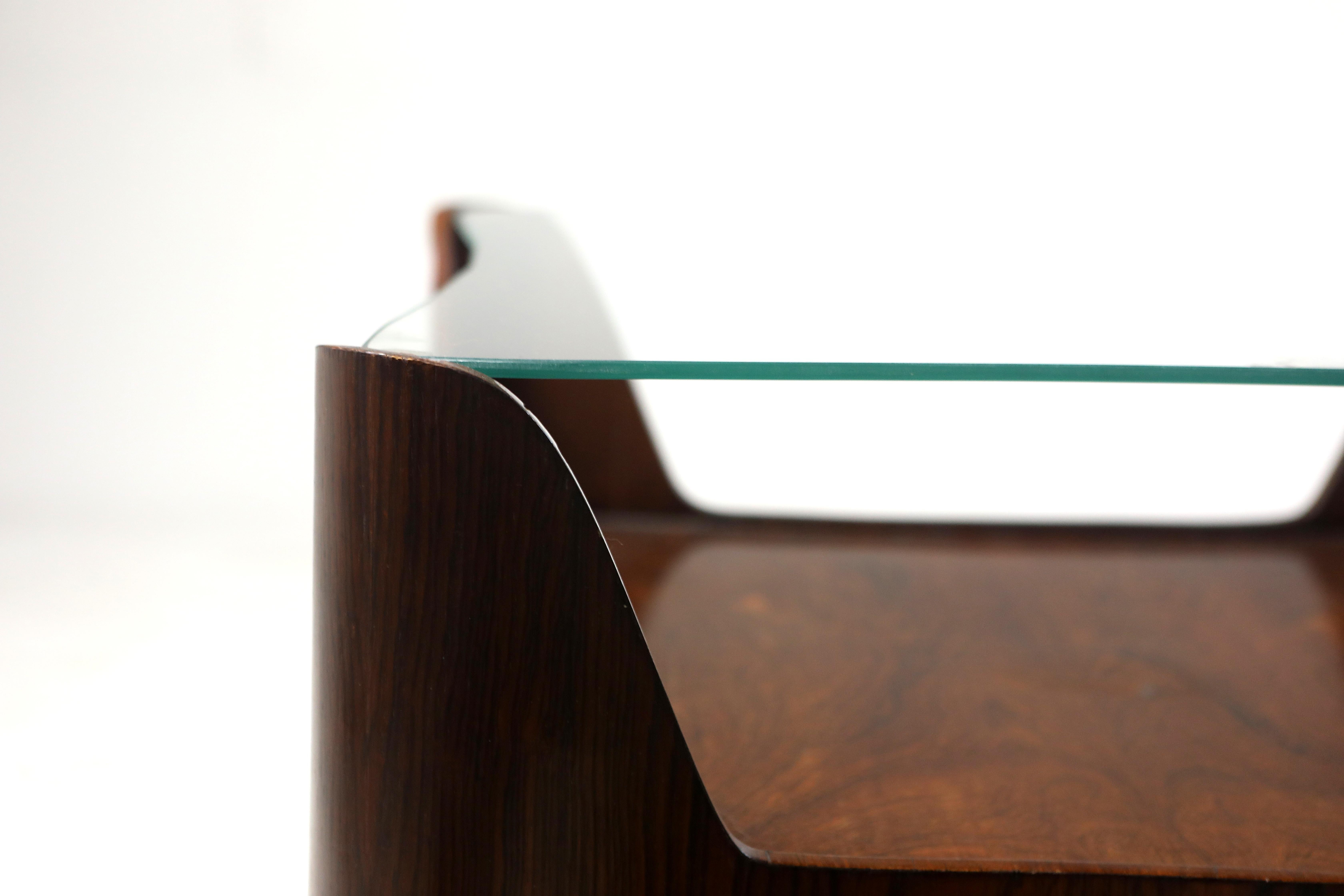 Mid-Century Modern Square Glass-Top Hardwood End Table, Brazil, 1960s

Structured in molded plywood revested in hardwood veneer, this 1960s square end table features a glass-top over a shelf, creating a nice display for curios and books. 
This piece