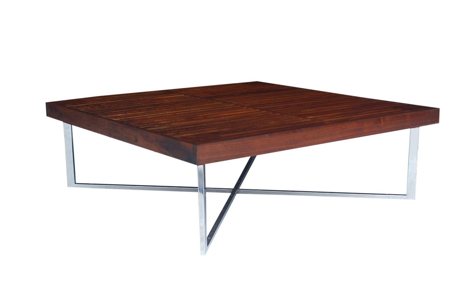 A super unique low profile coffee table in the style of George Nelson. It features a slatted walnut top with polished steel X-base. Very chic looking.