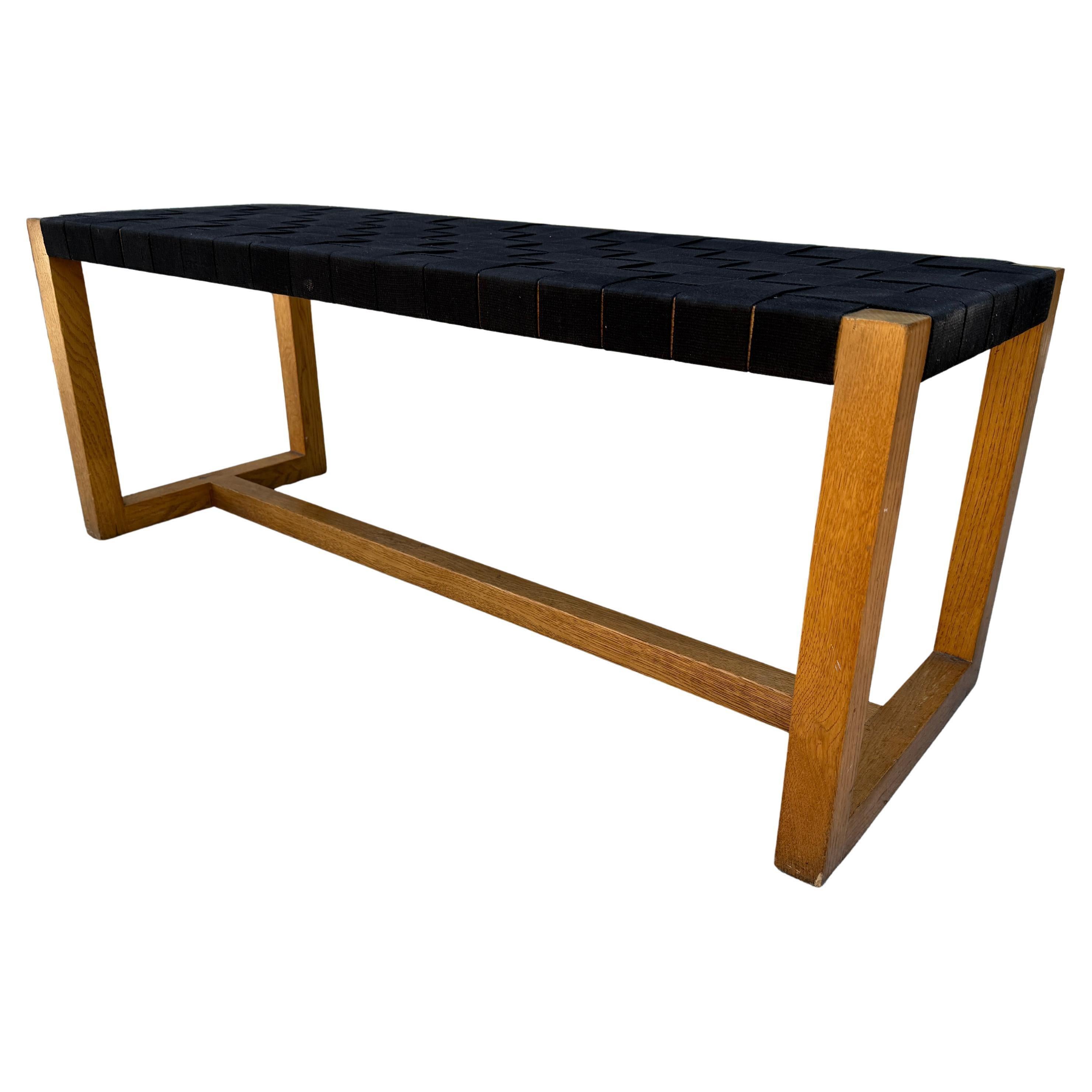 Banc moderne du milieu du siècle à structure carrée en chêne massif et toile tissée noire. En bon état vintage, toutes les sangles sont serrées et montrent peu de signes d'utilisation. Cadre en chêne très solide - robuste. Superbe banc en tissu. Non