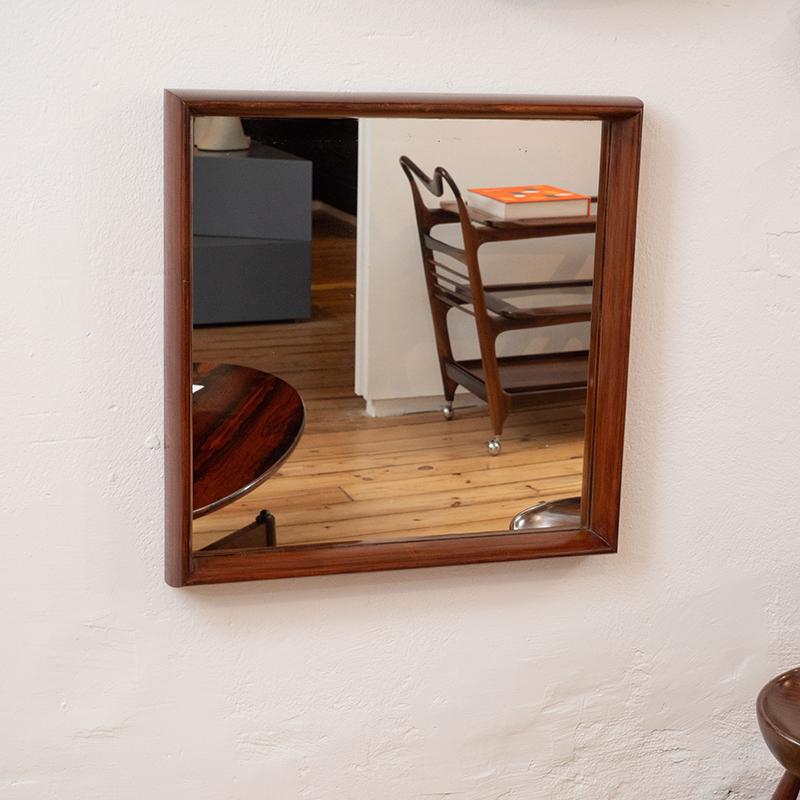 Mid-Century Modern square wall mirror nestled in solid wood frame, Brazil, 1960s

This beautiful vintage wall mirror was manufactured circa 1960s in Brazil. It features the fine woodwork of a solid wood frame with rounded-edges, finished in natural
