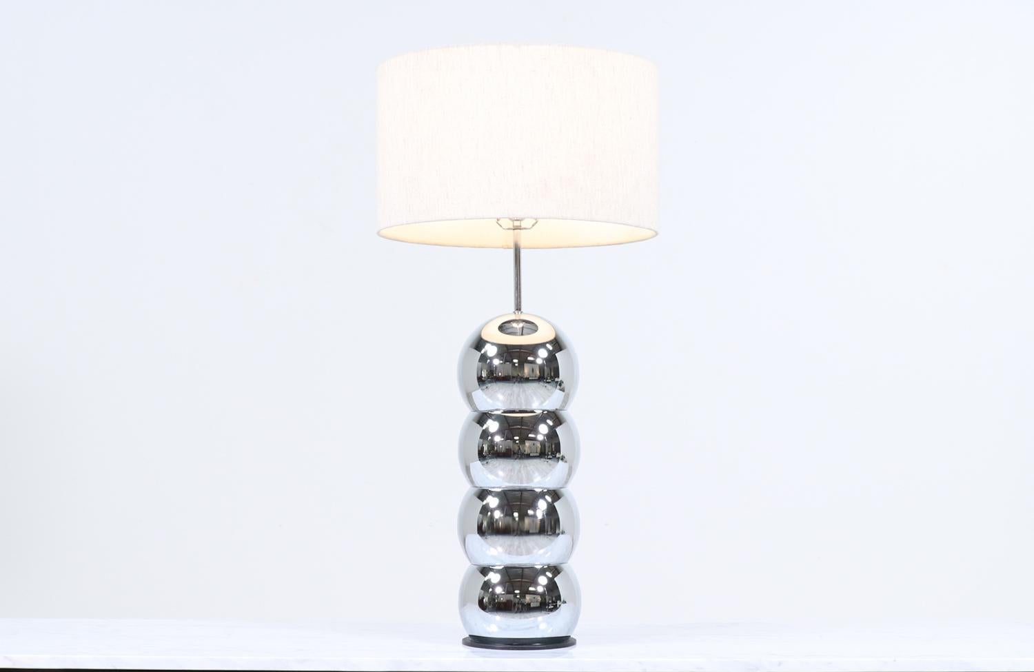 Amazing orb table lamp designed and manufactured by George Kovacs in the United States circa 1970’s. This unique lamp features four spheres that comprise the body, which are connected vertically. Set in chrome, the body supports the new linen shade