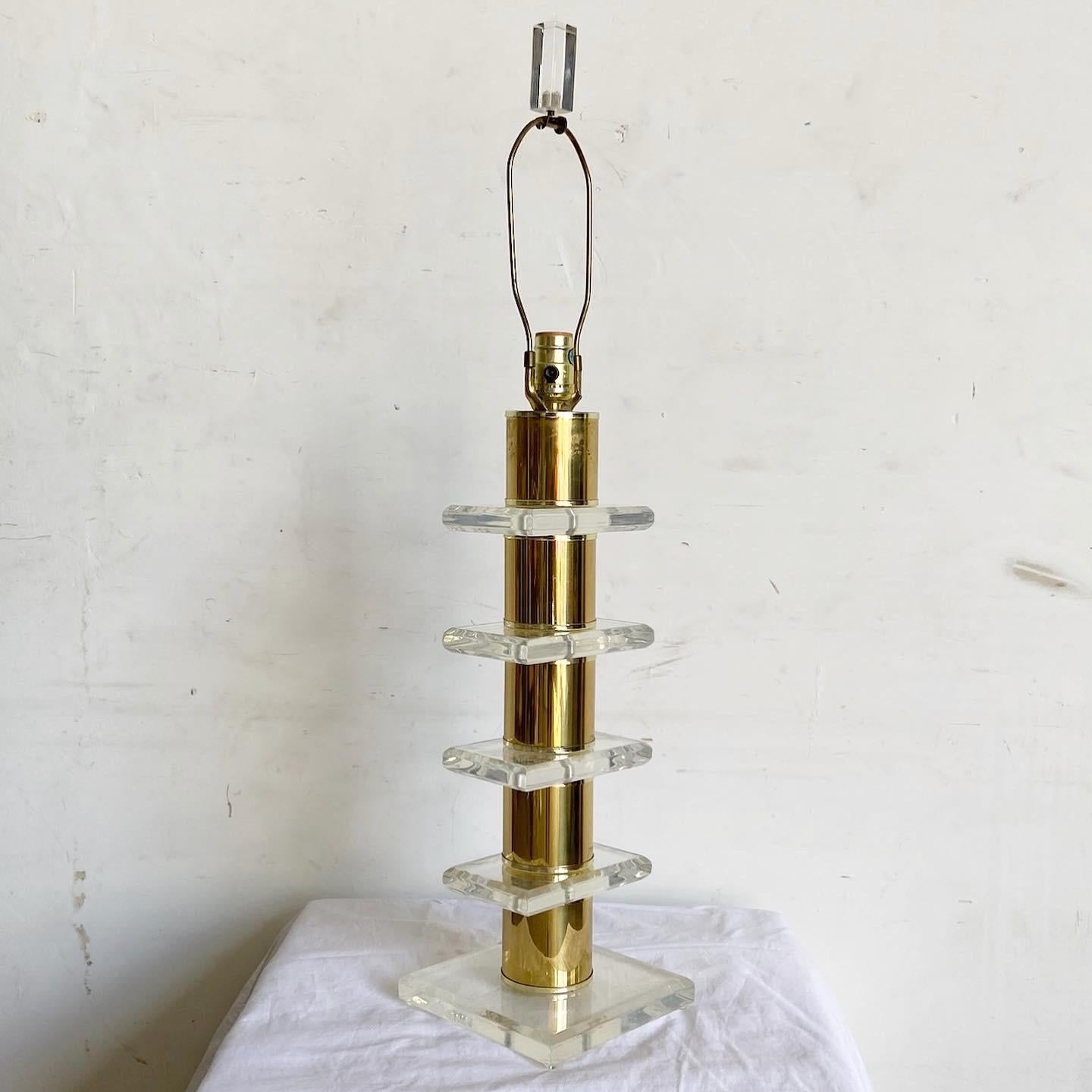 Step into the world of retro-modern elegance with this Lucite Gold Mid Century Lamp. The stacked Lucite design, complemented by gold accents, captures the essence of Mid Century Modern aesthetics. Its translucent layers play with light, offering