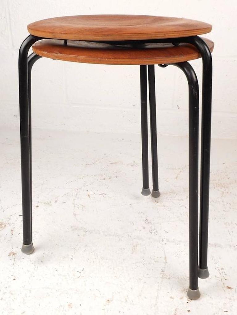 Beautiful pair of vintage modern nesting tables by designer Tony Paul feature circular birch wood tops and a bent rod iron frame. Unique tabletop sits on a tripod base with rubber feet. Versatile design can be used as end tables or small stools