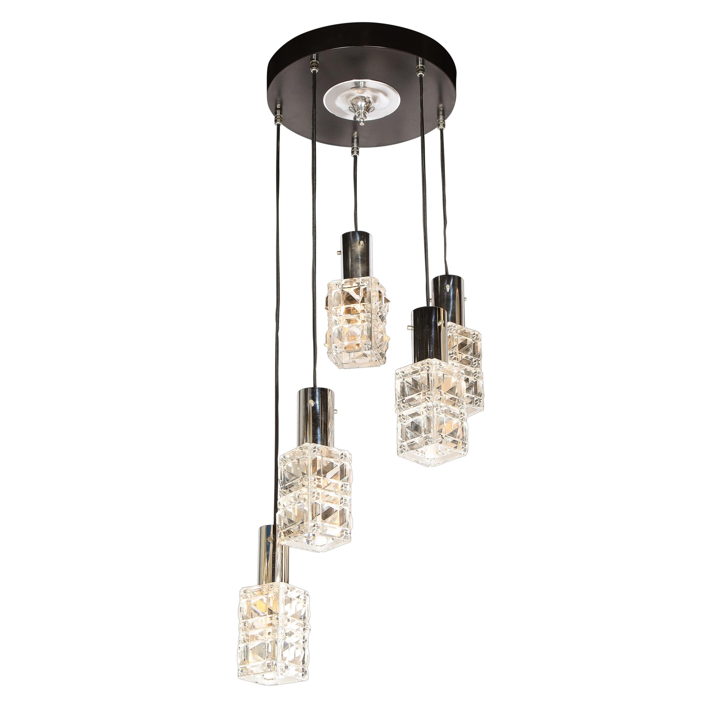 This stunning Mid-Century Modern chandelier was realized in Austria circa 1970 by the esteemed studio of Kinkeldey. It features a circular canopy in black enamel with polished chrome center five staggered shades hang via black silk cord. The shades