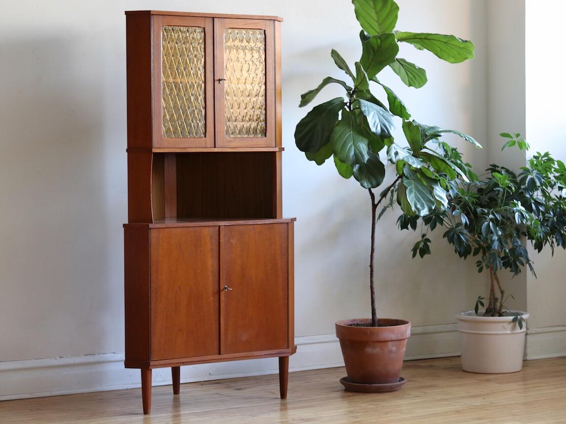 Scandinavian Mid-Century Modern locking liquor corner cabinet.
Just imported from Denmark!
teak wood with yellow-gold stained glass.
Two locking cabinet doors with adjustable shelving.
Comes with 2 vintage keys.
Excellent vintage