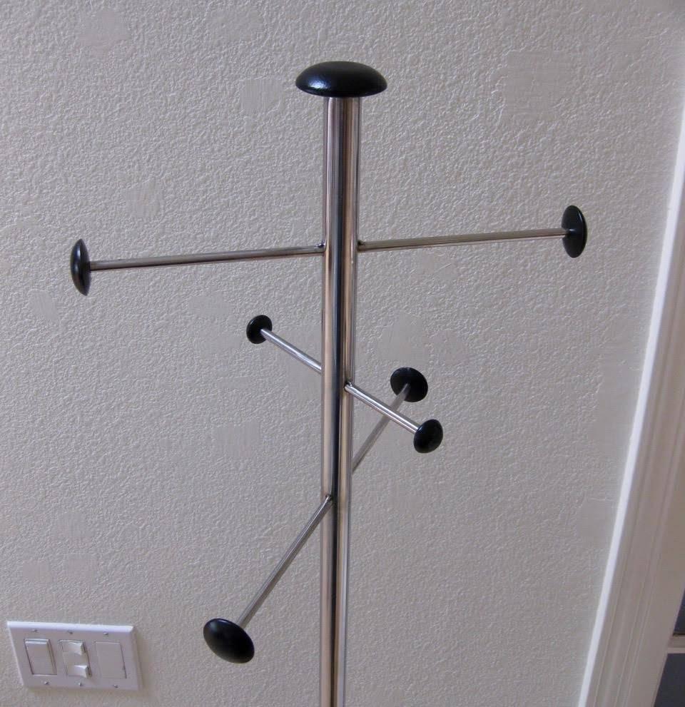 Mid-Century Modern six-foot hat/coat/umbrella stand with black painted wood knobs attached to a stainless steel frame and a weighted, black metal base. Sturdy, stylish and simple design.
 