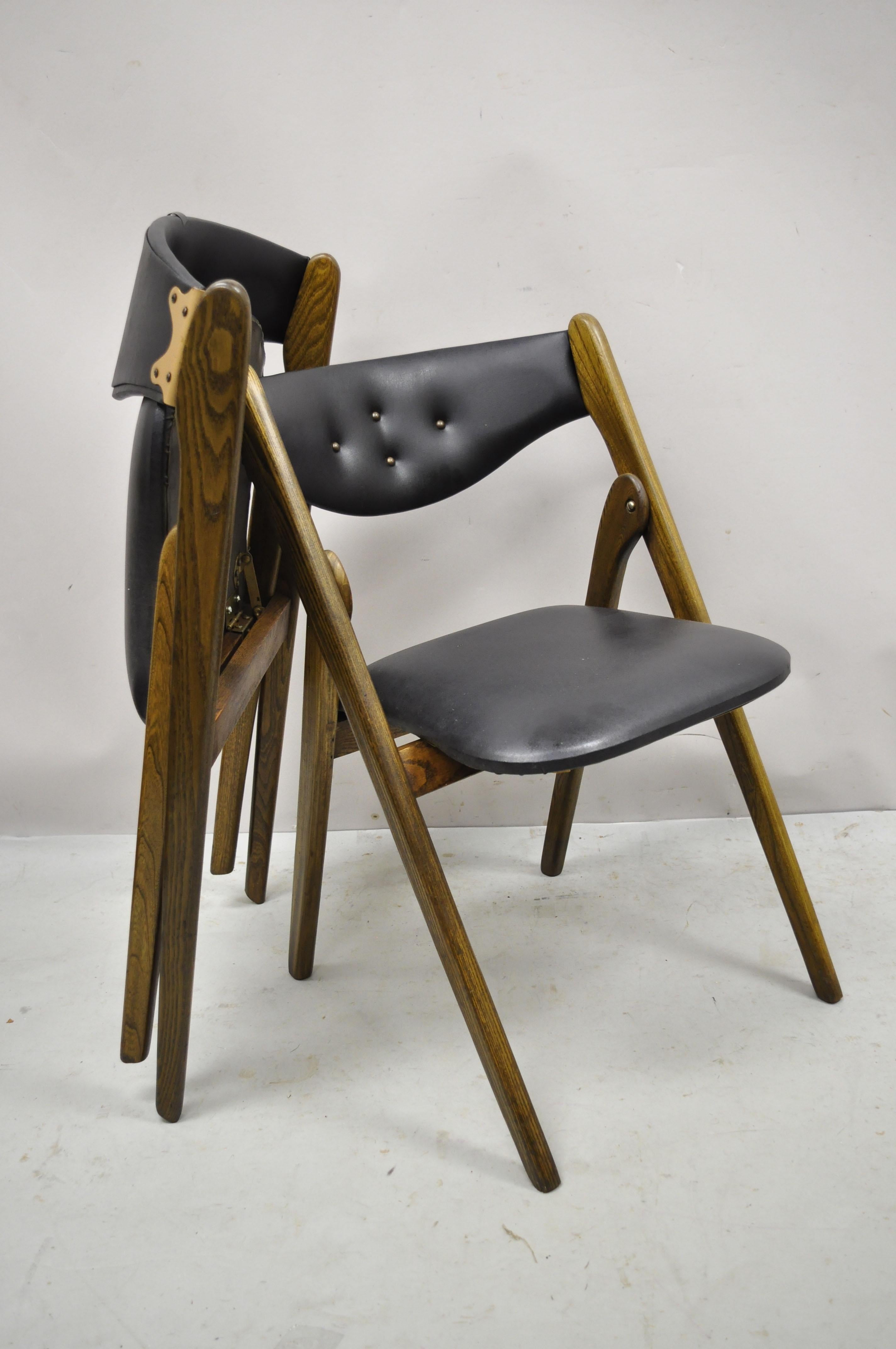Vintage Mid-Century Modern stakmore black folding chairs card dining chair - Set of 4. Item features black naugahyde upholstery, folding frames, original label, tapered legs, very nice vintage set, sleek sculptural form. Circa mid 20th century.