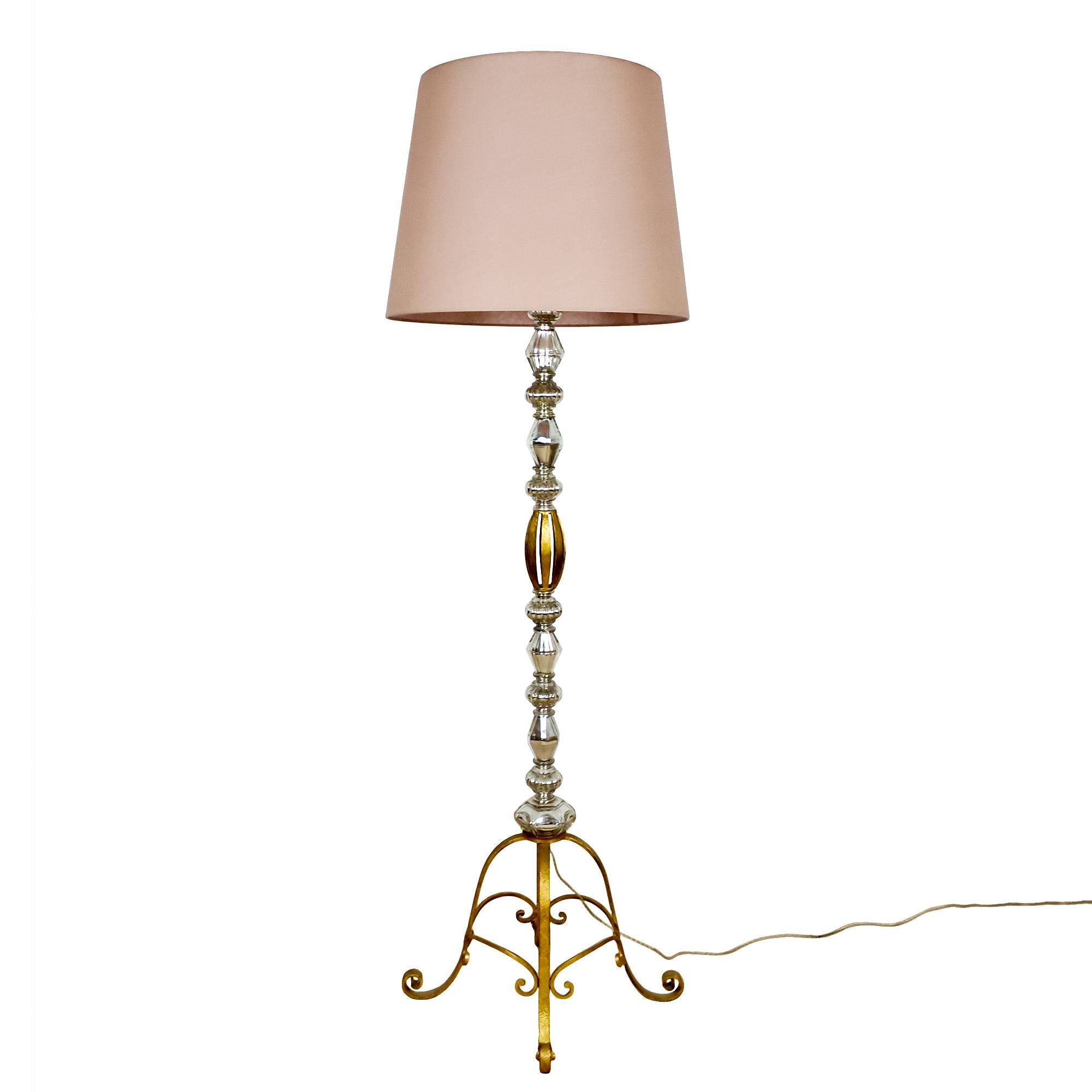 High quality standing lamp with a golden wrought iron structure and eleven pieces of silvered blown glass. Brass double lightning system and diffuser for the lampshade, three bayonet bulbs.
France c. 1940

Measurements:
Base: 39 x 39 cm.