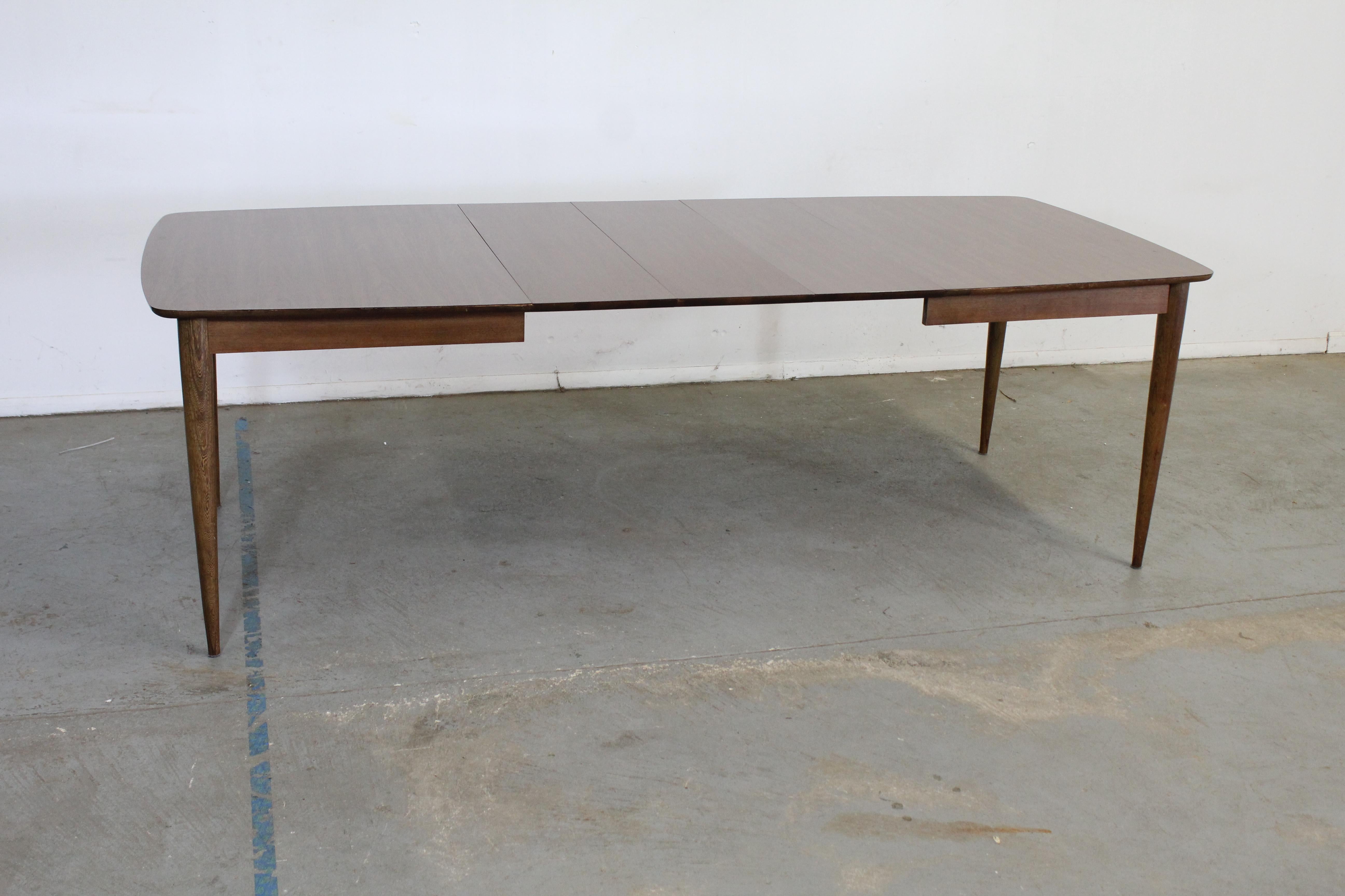 Mid-Century Stanley walnut surfboard dining table

Offered is amid-century modern vintage dining table that was designed Stanley Furniture. This table features a laminate top with tapered walnut legs. In good condition with some surface scratches