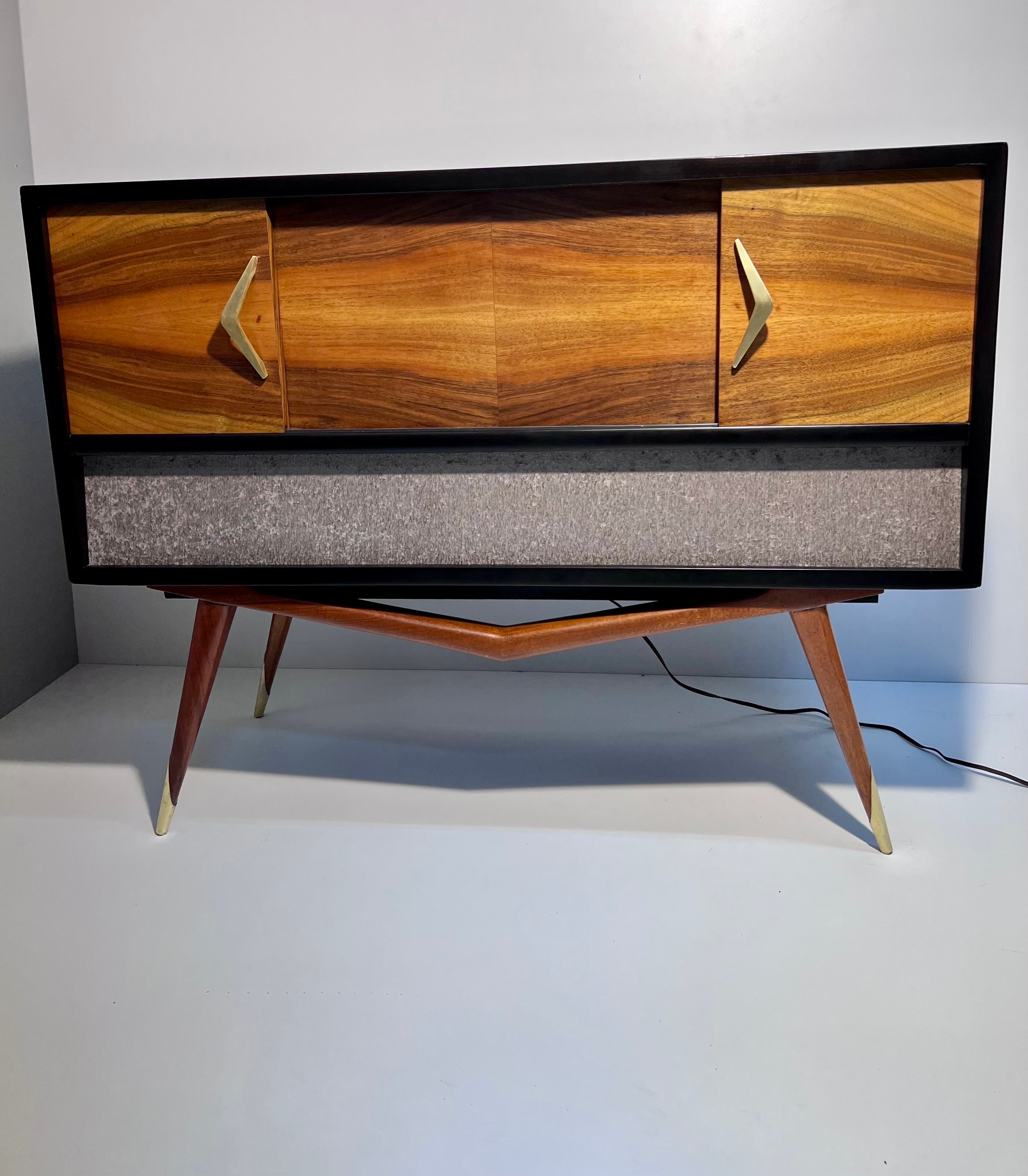 Spectacular midcentury console made in Mexico in the early 1960s, mahogany, elm and pine wood with brass details. We added new Bluetooth audio equipment as the original system we believe does not work. The entire exterior and interior was
