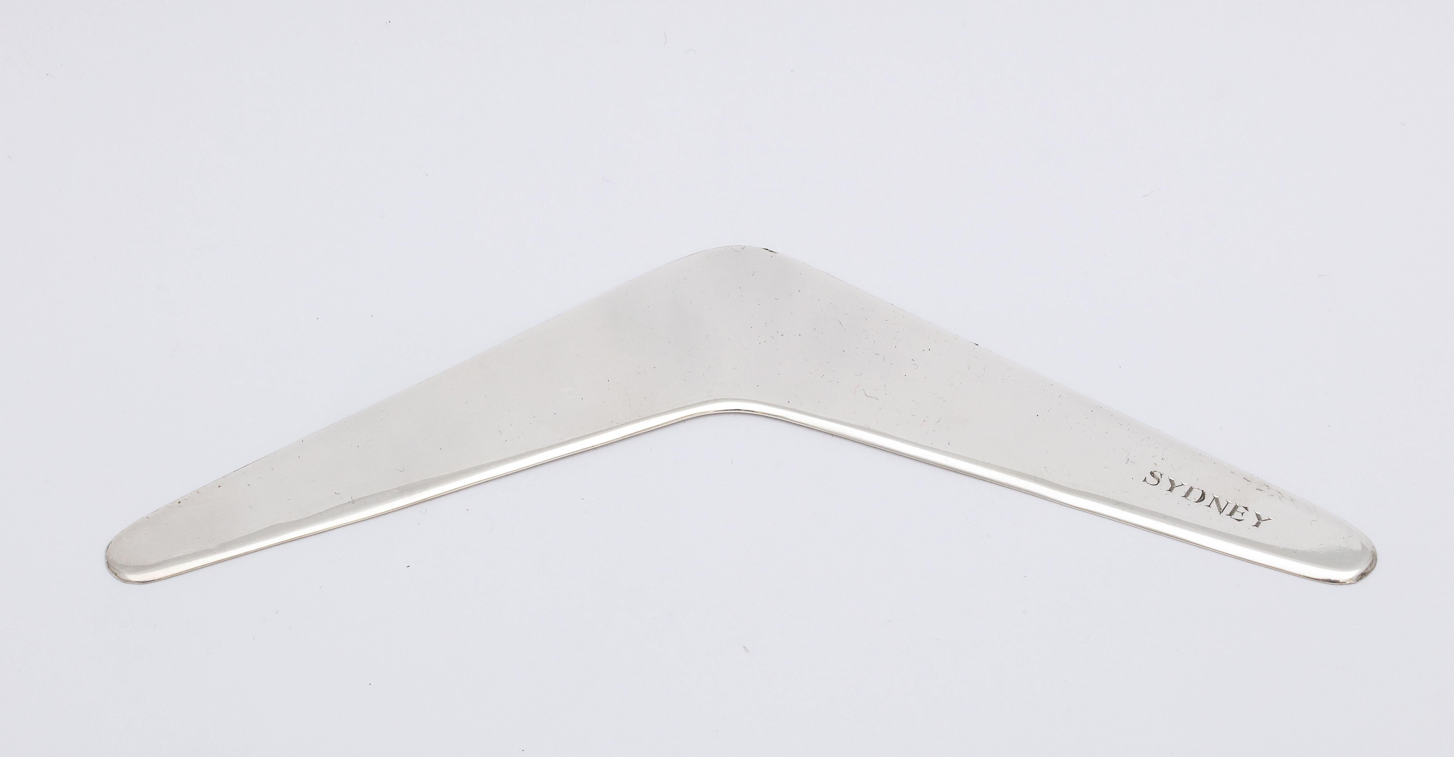 Mid-Century Modern, sterling silver boomerang, Australia, circa 1950s, Britannic - maker. Measures 6 inches from end to end x 1 1/8 inches deep at deepest point x 1/23 of an inch high when lying flat; weighs 0.920 troy ounces. Inscribed SYDNEY in