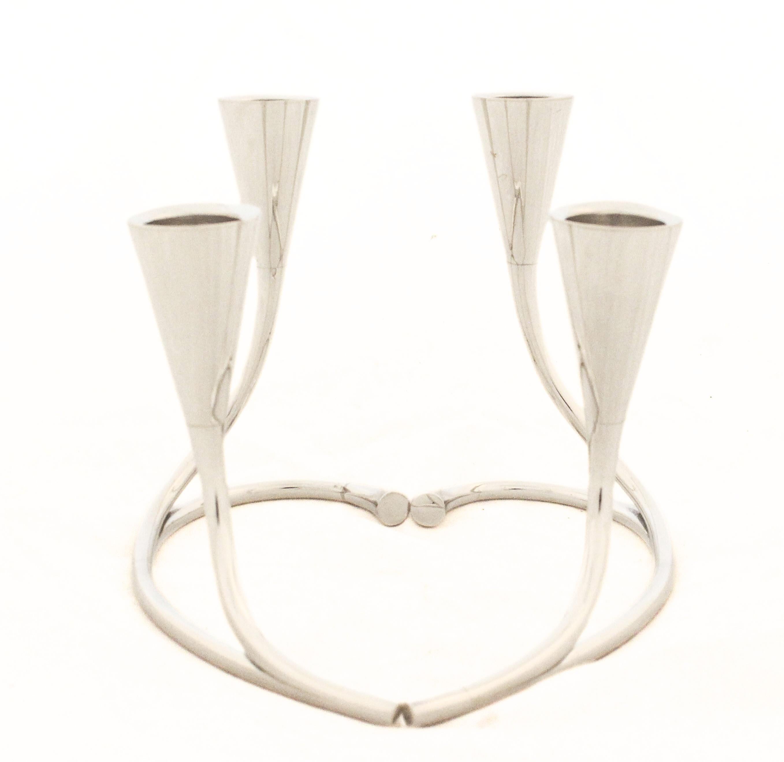 Questa splendida coppia di candelabri in argento sterling in stile Mid-Century Modern incarna le linee pulite e l'eleganza scultorea tipiche dell'epoca. Ogni candelabro presenta due rami graziosamente curvati che si ergono da una base liscia. Quando
