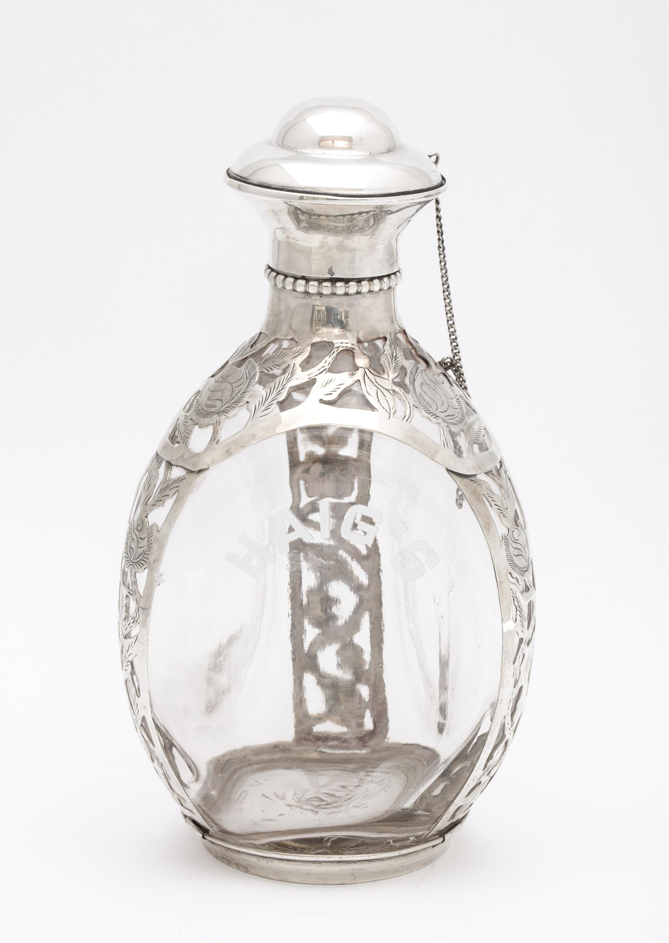 Mid-Century Modern, sterling silver floral overlay - mounted glass Haig's Scotch decanter, Mexico, Ca. 1955. Decanter is hand blown glass, signed with the Haig's mark. Sterling silver has a Mexican hallmark. The company name, Haig's, is enameled on