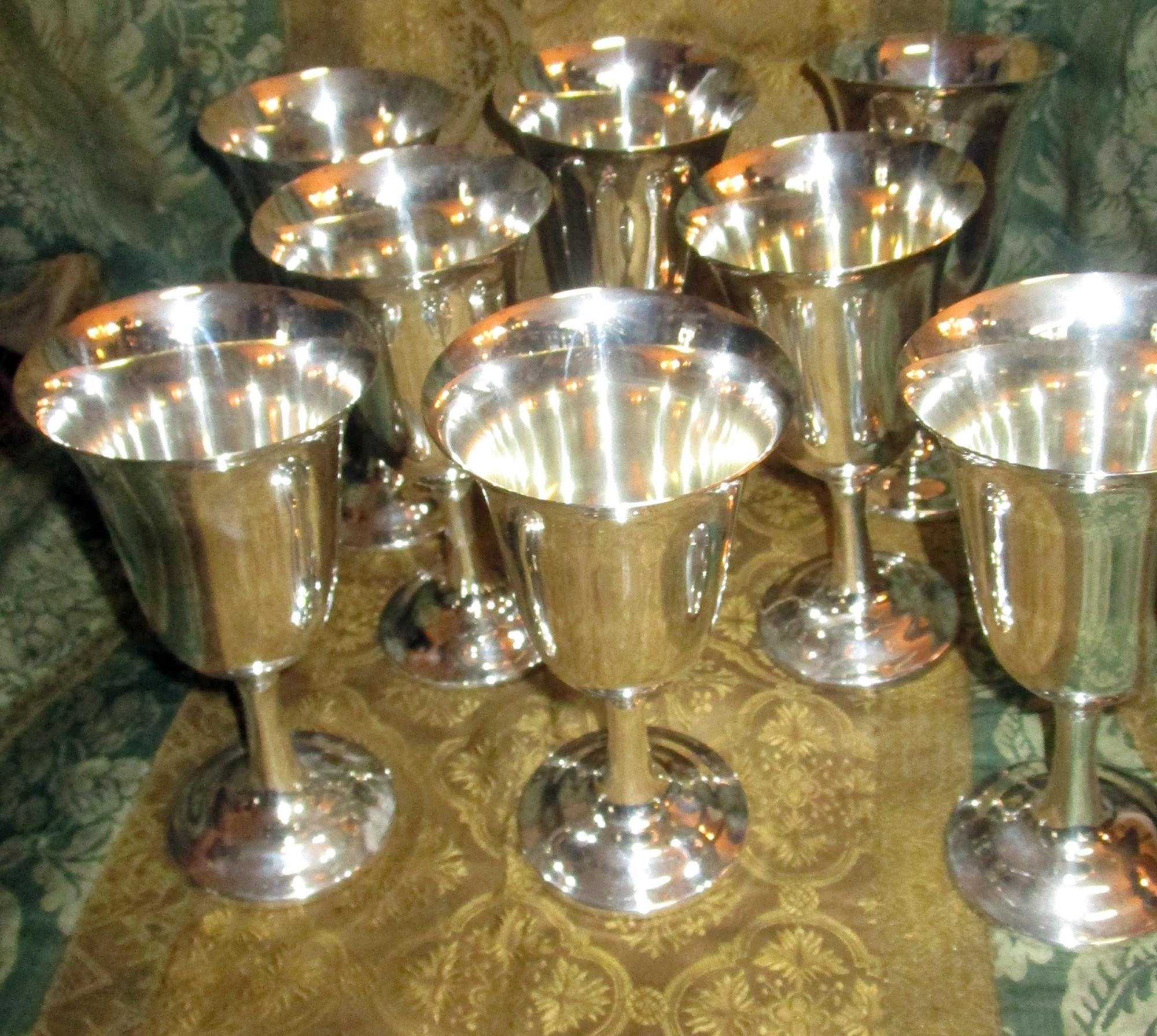 Handsome sterling silver water goblets by Wallace silversmiths, Wallingford, Connecticut. Set of eight pieces featuring classic lines of graceful bell shaped form on an incurved stem and circular foot. Maker's mark of Wallace Silversmiths, number