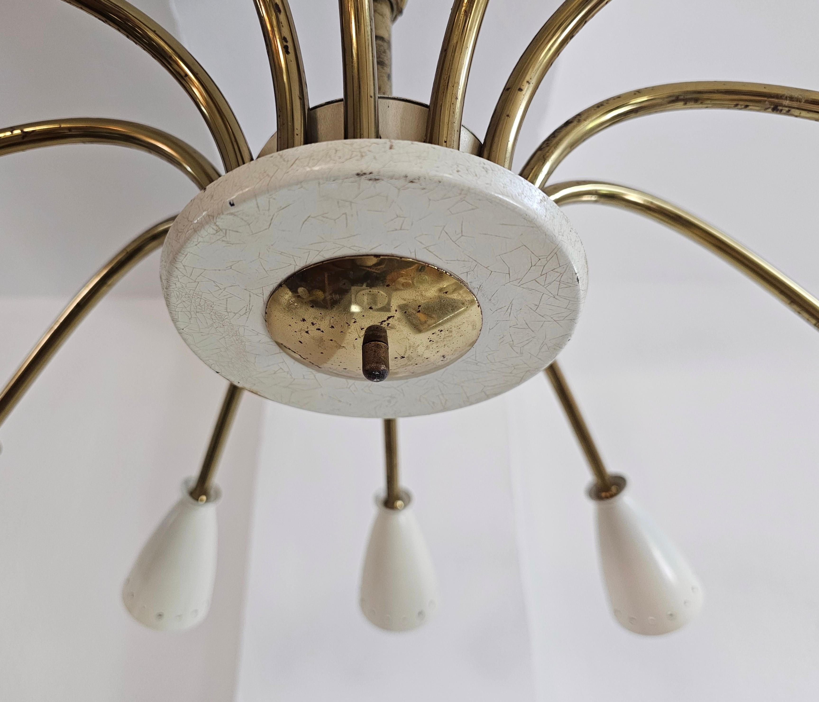 In this listing you will find a stunning 12-Arm Mid Century Modern Chandelier by Stilnovo (attr.). It is done in brass and painted brass (off-white or ivory), with 12 lights ordered in spider or sputnik form. Chandelier was made in Italy in