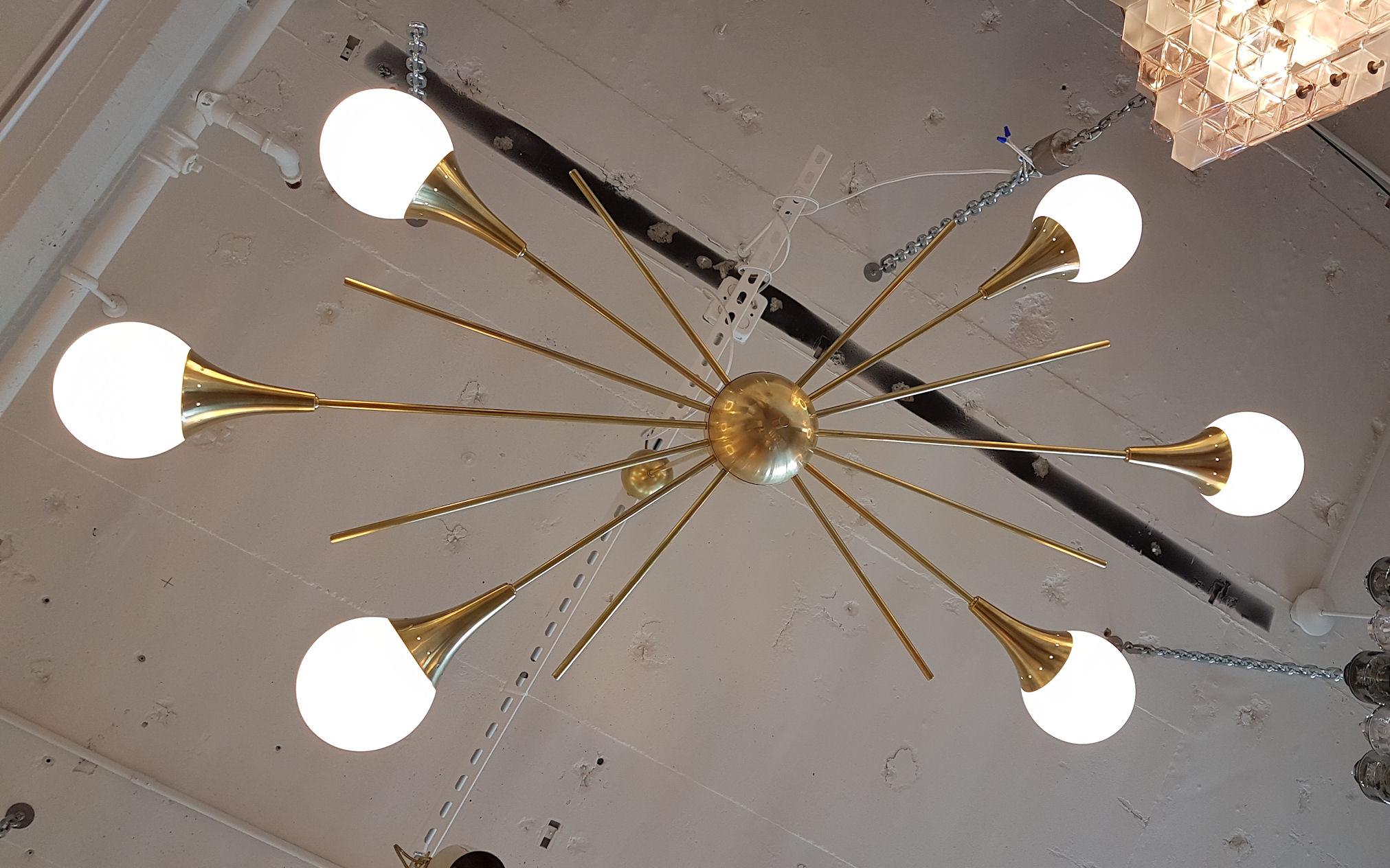 Mid-Century Modern Italian, Stilnovo style, six-arm brass and six white glass globes, Sputnik chandelier.
Made of a brass centre ball, with six brass tubes at the same height on each side.
Beautiful patina on the brass.
The height is adjustable