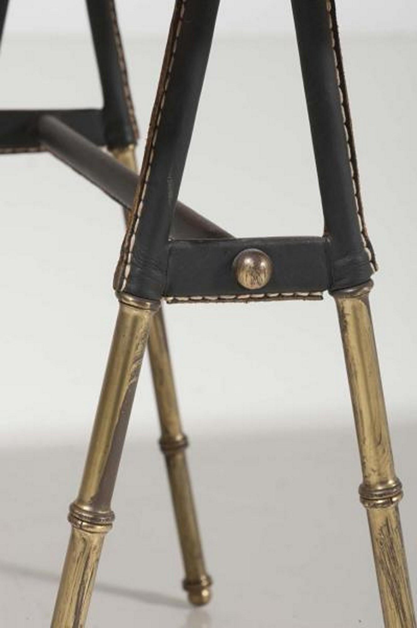 Exceptionnelle et rare table basse du célèbre designer français Jacques Adnet. Cette table utile et pratique est un design classique de haute qualité typique de ses meilleurs travaux. Les pieds sont en laiton dans son célèbre style faux bambou avec