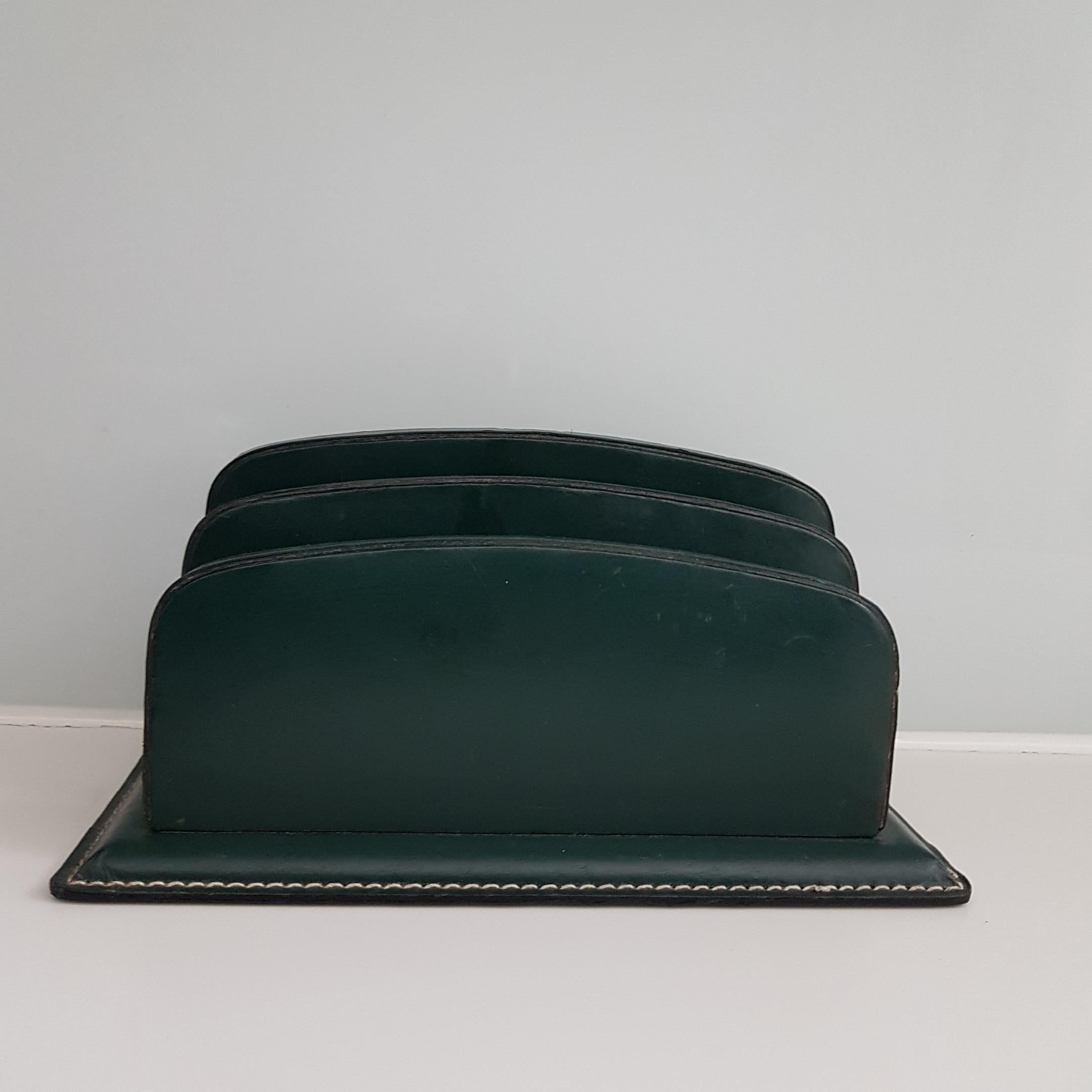 Ein klassisches genähtes Lederschreibtischset in dunkelgrünem Leder, das Jacques Adnet zugeschrieben wird. Das Set besteht aus einer Uhr mit Aufzugsmechanismus und vernickelten, stilisierten Zahlen auf dem Zifferblatt im Art-déco-Stil. Die Uhr, die