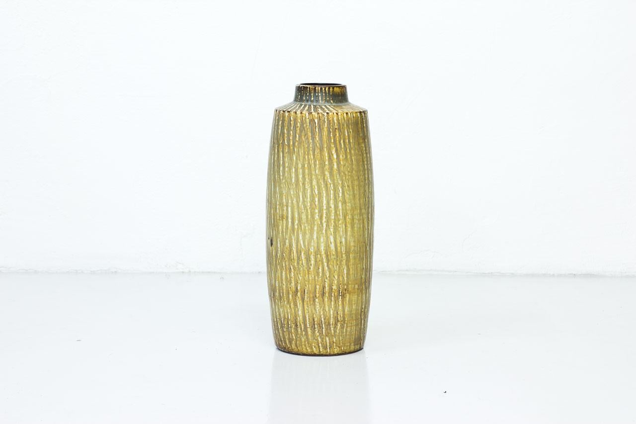 Tall stoneware floor vase designed by Gunnar Nylund as part of the “Rubus” serie for Rörstrand, Sweden during the 1950s. Stoneware in beige, gray and brown mottled matte
glaze, nubby surface. Hand signed with initials of ceramist.