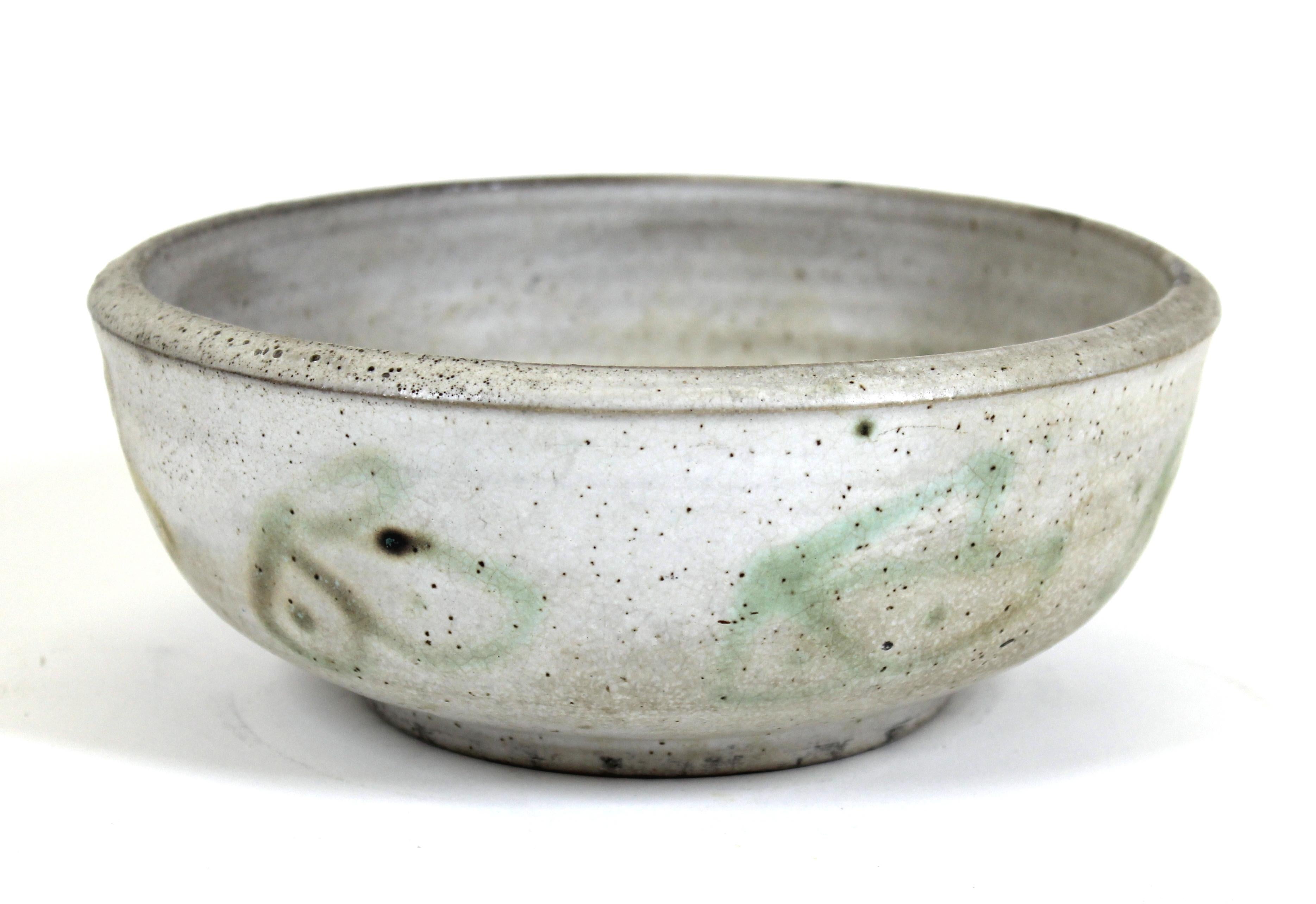Mid-Century Modern glazed stoneware pottery bowl with abstract decorative drawings inside and outside, signed illegibly on bottom.