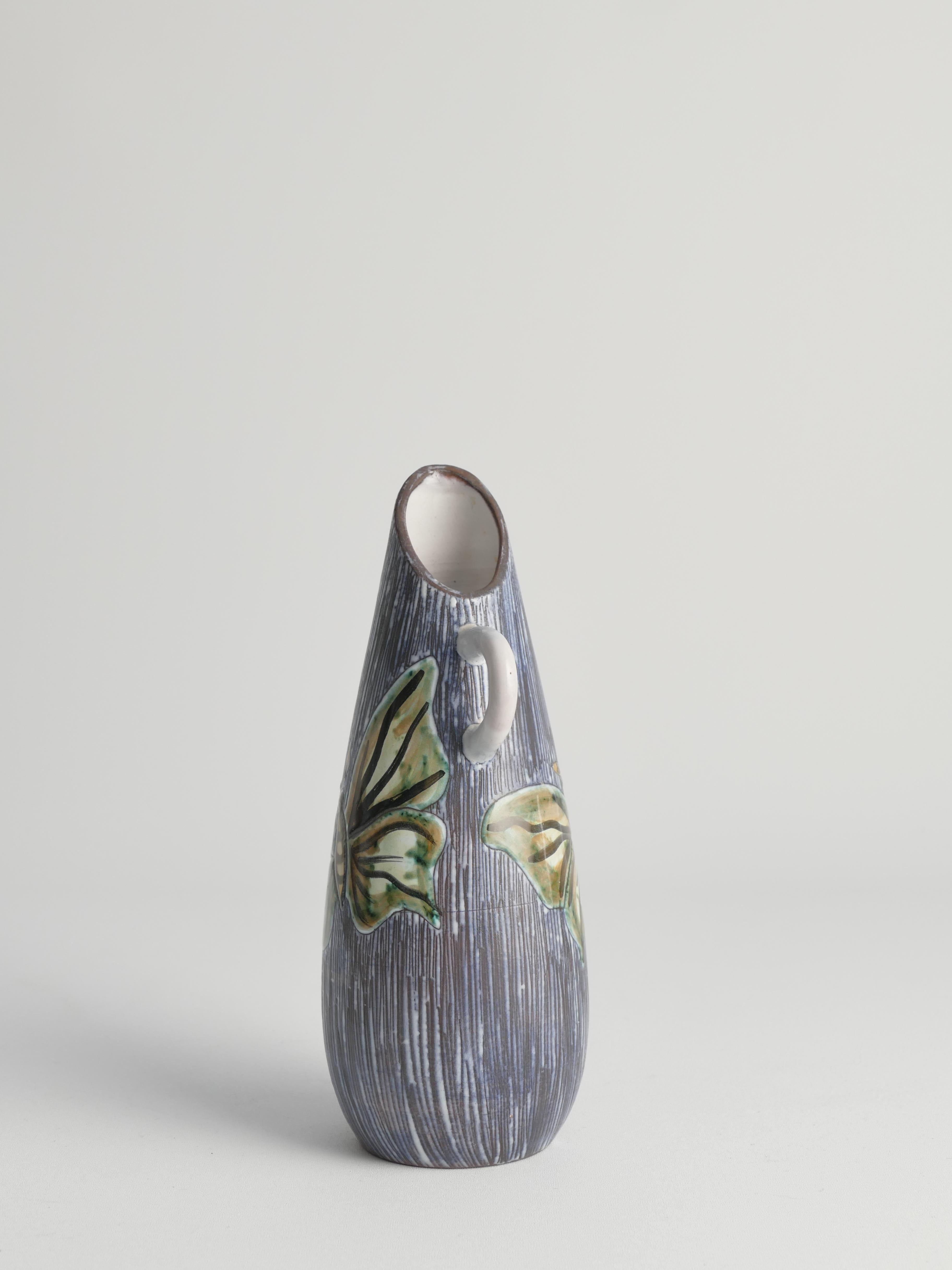 Handgeformte Vase aus Steingut mit Sgraffito-Technik und Schmetterlingen, Schweden 1950er Jahre 

Diese in den 1950er Jahren handgefertigte und handdekorierte Vase aus Steinzeug stammt wahrscheinlich aus Alingsås, Schweden. Die Vase hat einen