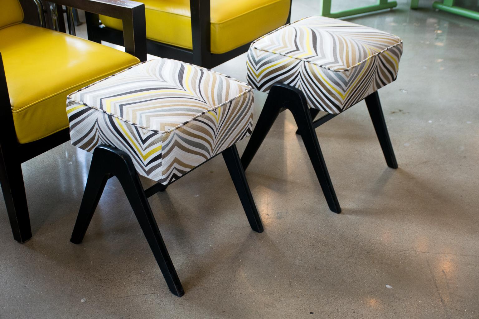 Italian Mid-Century Modern stools with Classic V-legs in ebony finish and new custom upholstery. Upholstered in high end embroidered fabric from groundworks with shades of gray, bronze, black and yellow on natural ground.

See coordinating yellow