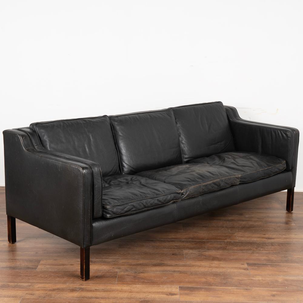 Mid-Century Modern vintage Stouby sofa, Eva model, in black leather.
Three-person sofa upholstered in black semi-analine leather, legs in stained beech.
Sold in vintage used condition.
Frame solid, sits low and comfortable. Wear on leather