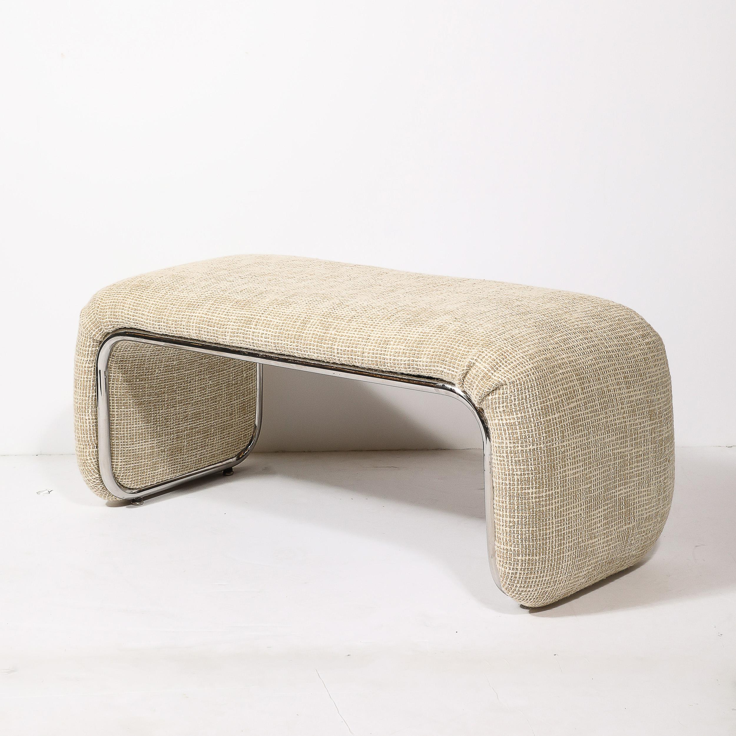 This glamorous Mid-Century Modernist waterfall bench was realized in the United States, Circa 1970. It features a dramatic streamlined form newly reupholstered in a beautiful Holly Hunt fabric. The supporting framework of the piece is fabricated in