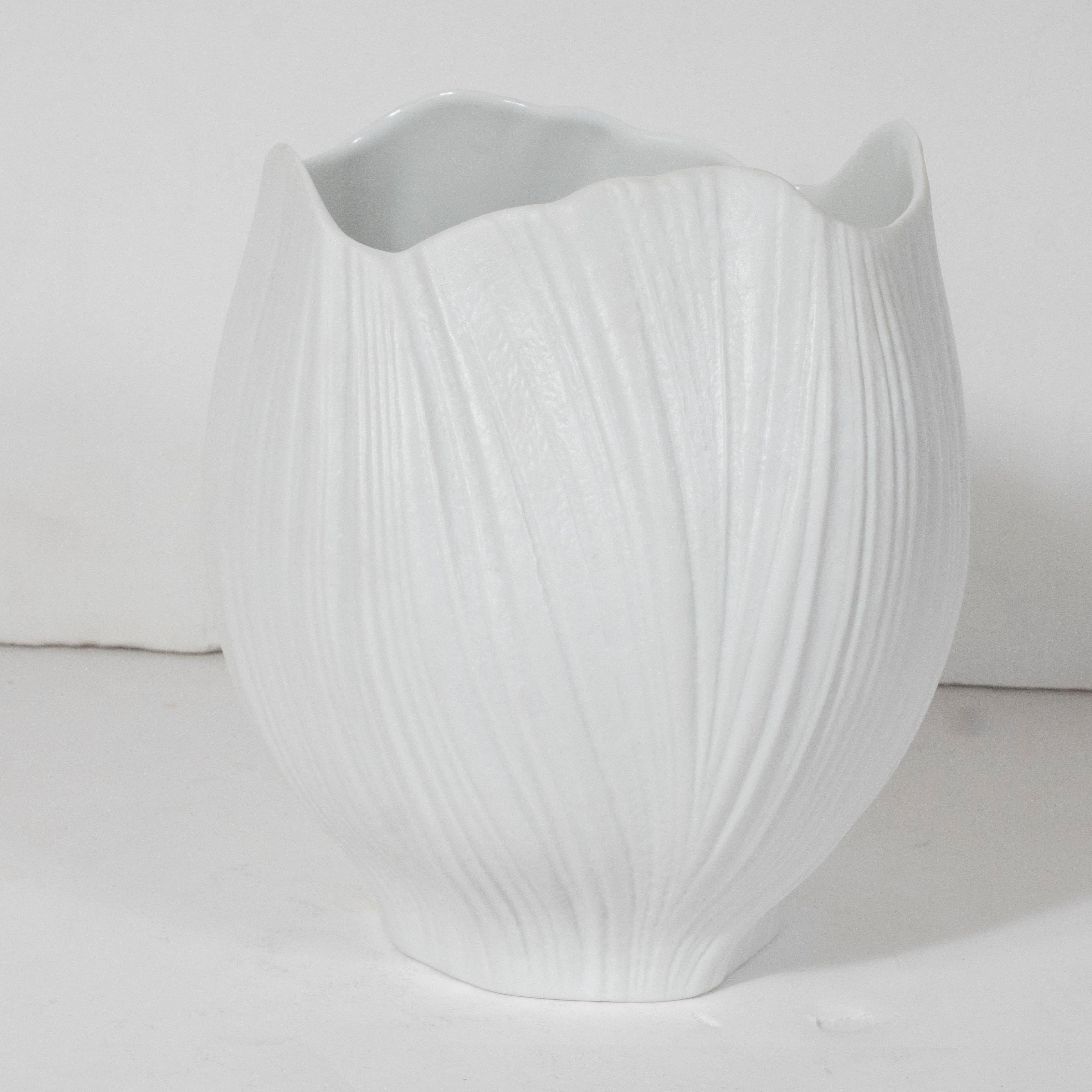 This stunning Mid-Century Modern vase was designed by Martin Freyer for Rosenthal circa 1980. It features an organic and sculptural form- full of verve and subtle movement- realized in striated white ceramic. With its beautiful quality and clean