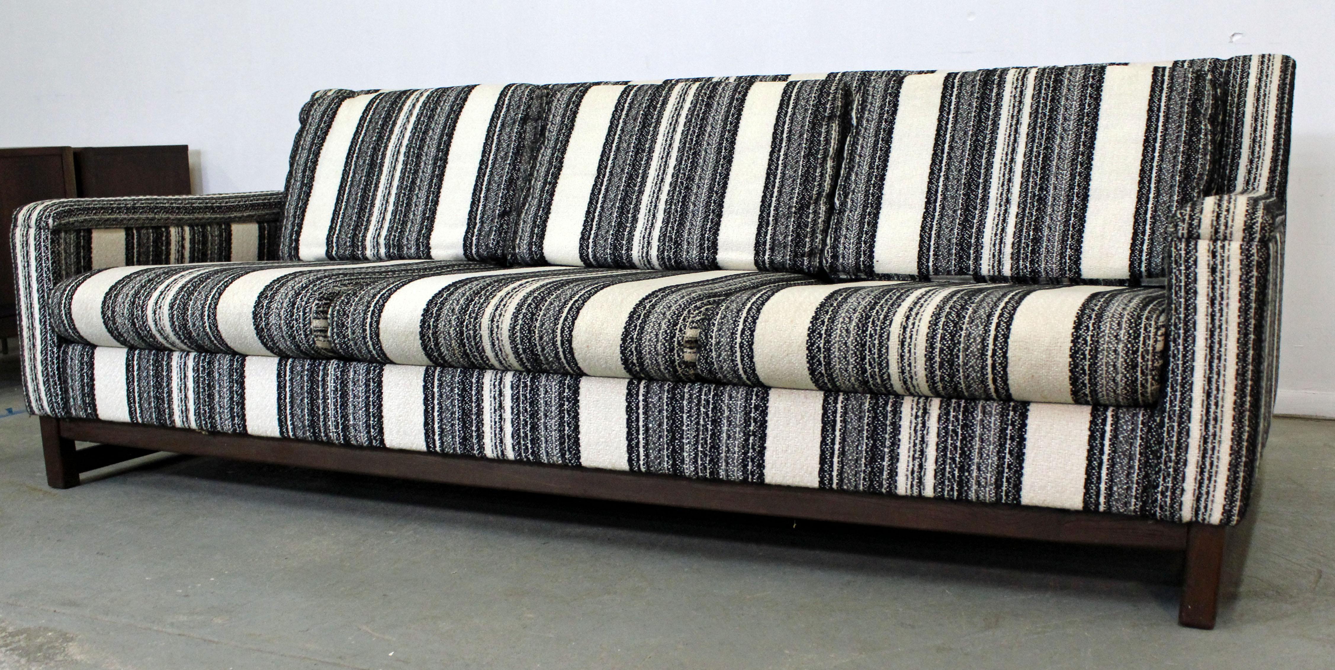What a find. Offered is a mid-century modern sofa made by Selig Imperial. This is a three-seater with striped upholstery and wooden legs. It is in good condition for its age with some wear including very light stains. It is branded by Selig