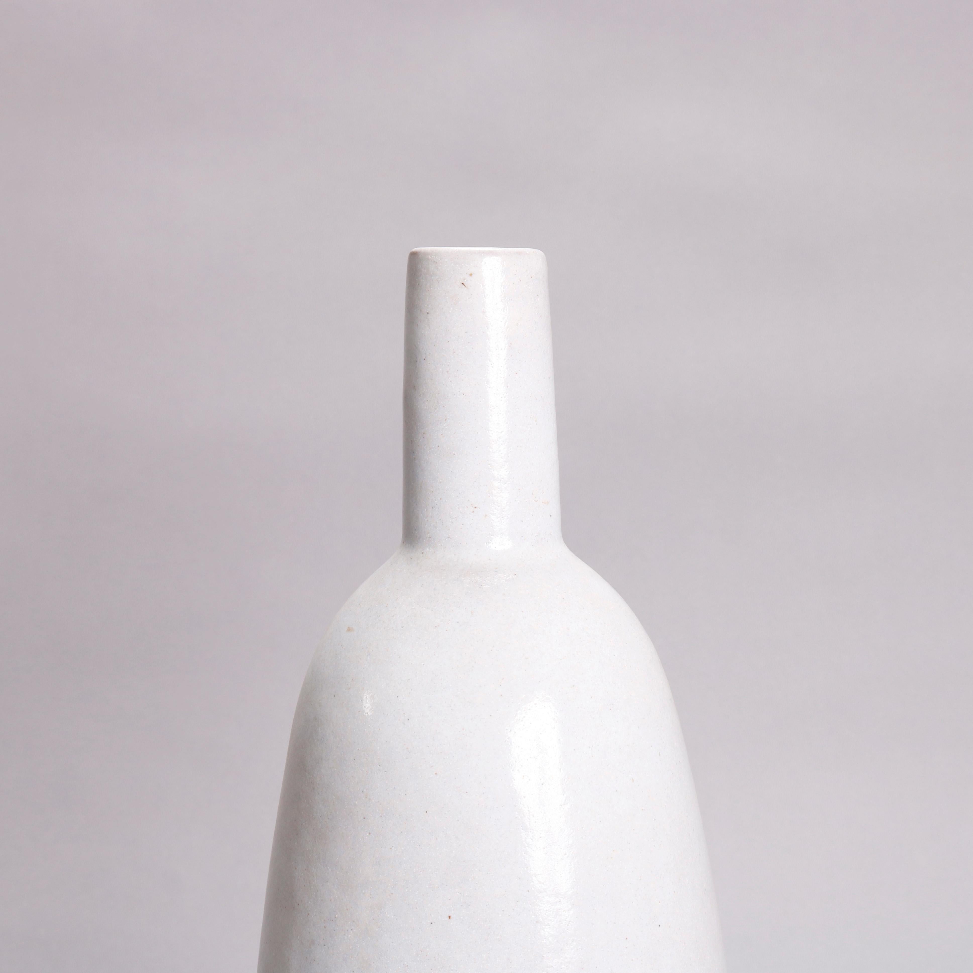 A Mid-Century Modern studio art pottery bottle vase offers bottle form with torpedo vessel, straight neck and having stone white glazing, artist signature on base as photographed, 20th century


Measures: 13.25