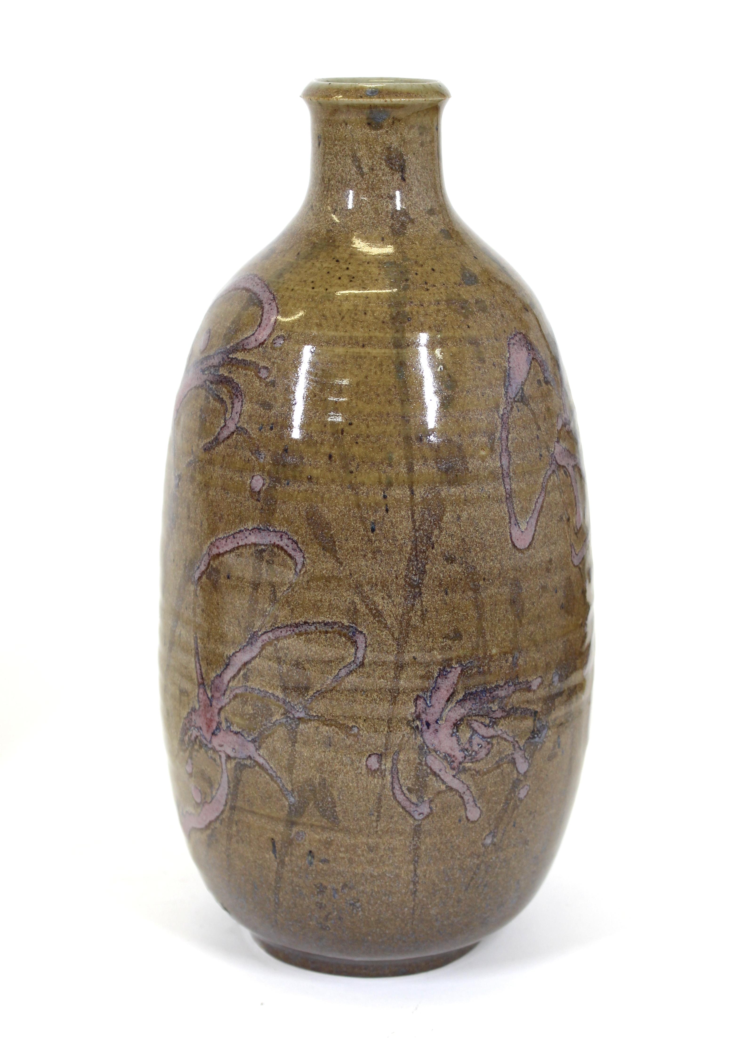 Mid-Century Modern glazed art ceramic bottle-shaped vase with purple floral decoration, signed illegibly on bottom.