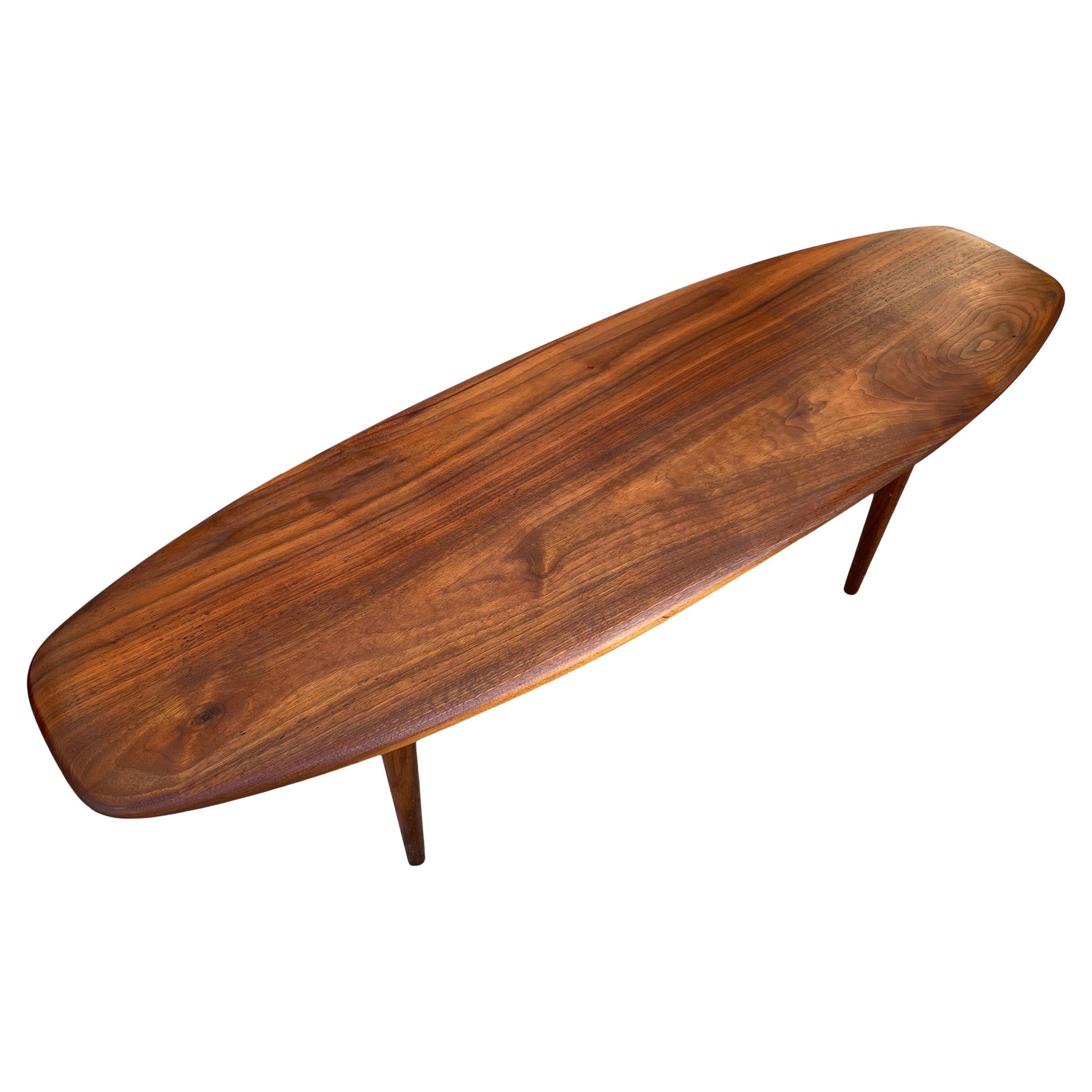 Mid-Century Modern Studio Craft small surfboard shaped solid walnut coffee table. Hand made Circa 1960s American Studio Craft Black Walnut Surfboard shaped coffee table. In the style of Phillip Lloyd Powell woodworker. Located in Brooklyn NYC.