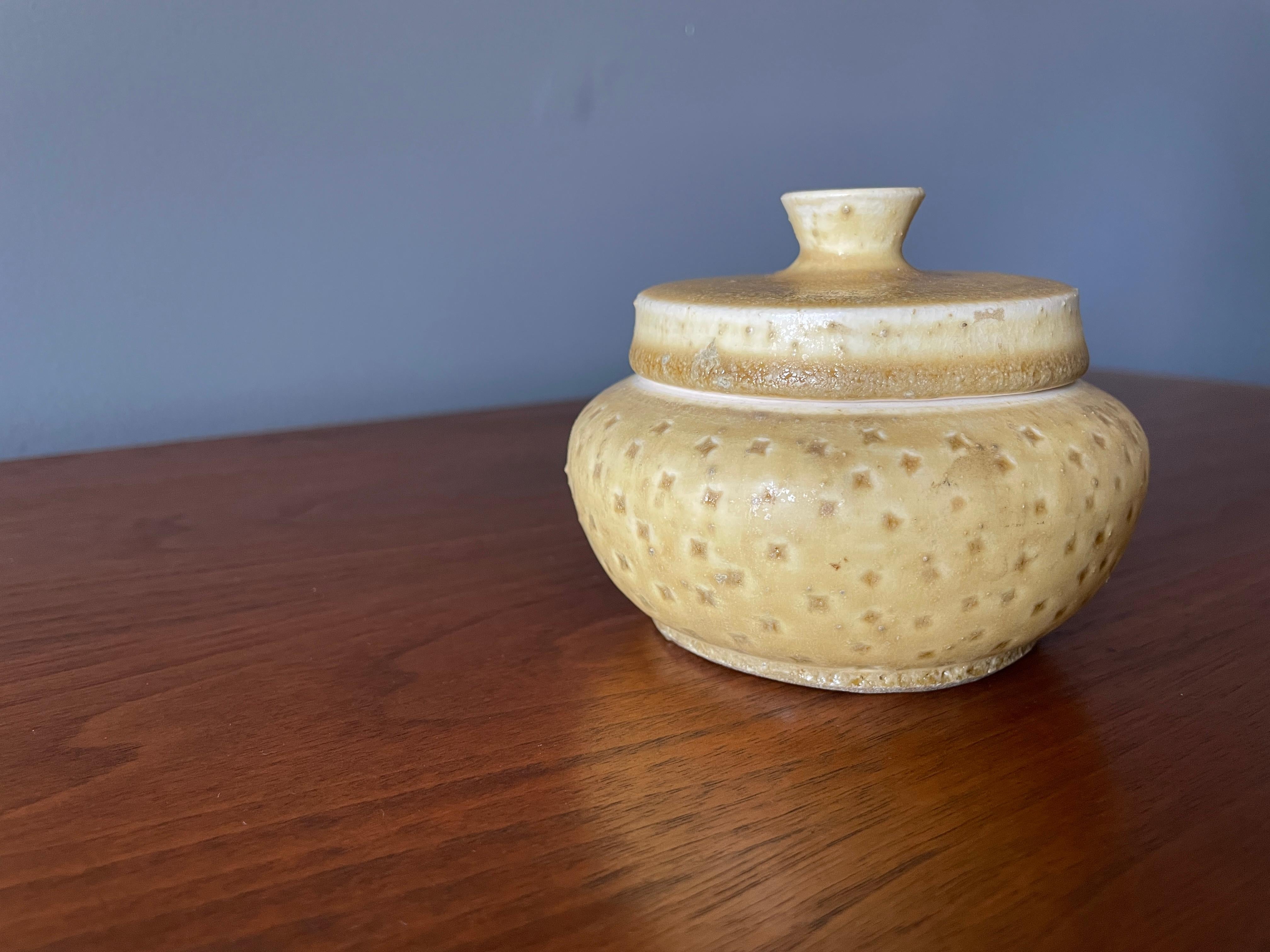Mid-Century Modern studio crafted ceramic lidded jar. Matte yellow with a subtle texture. Signed and dated by the artist.