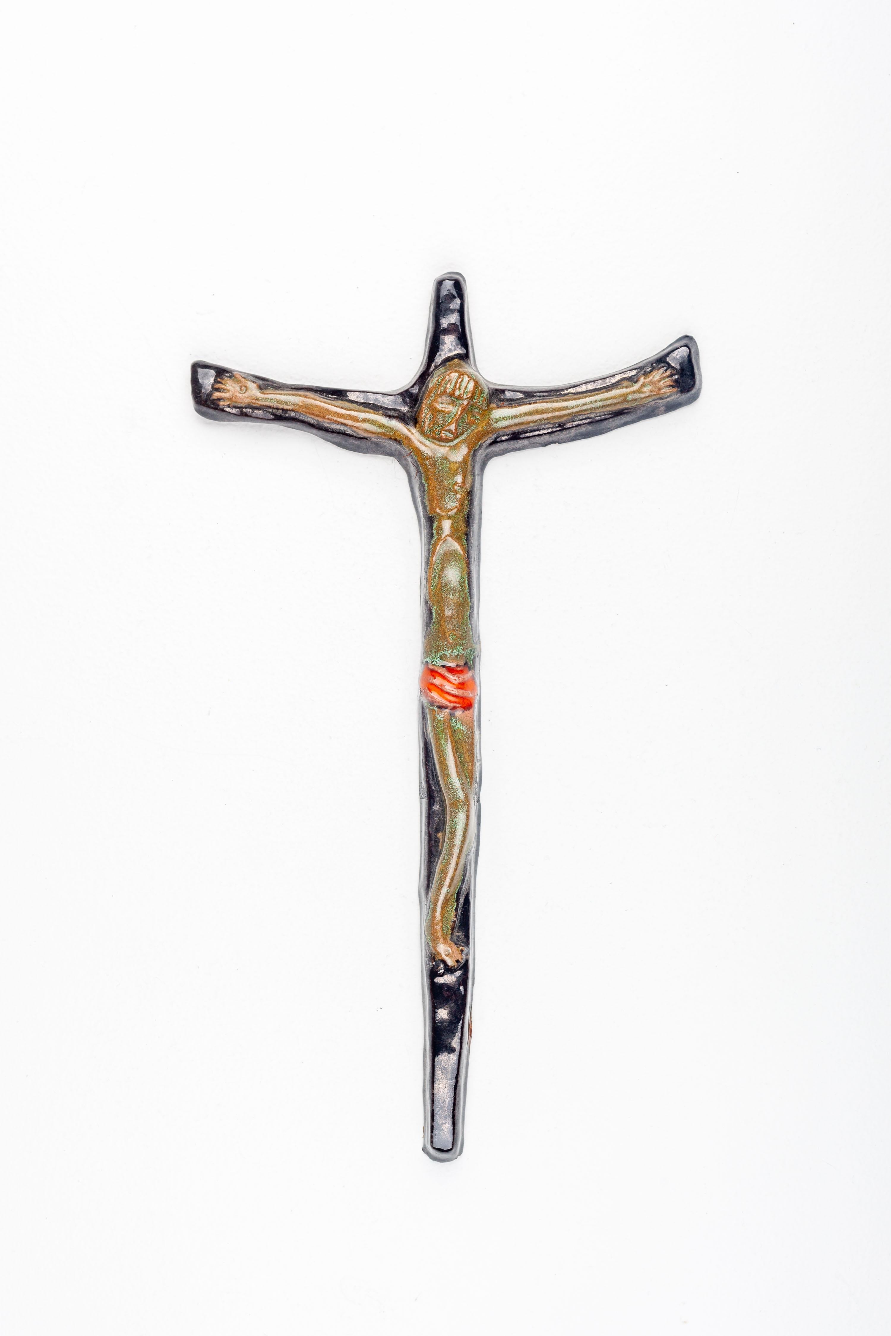 Cette croix murale en céramique est une pièce distinguée d'art religieux moderne du milieu du siècle, méticuleusement fabriquée à la main par des artistes européens de la poterie d'atelier. L'époque, connue pour ses lignes épurées et ses formes