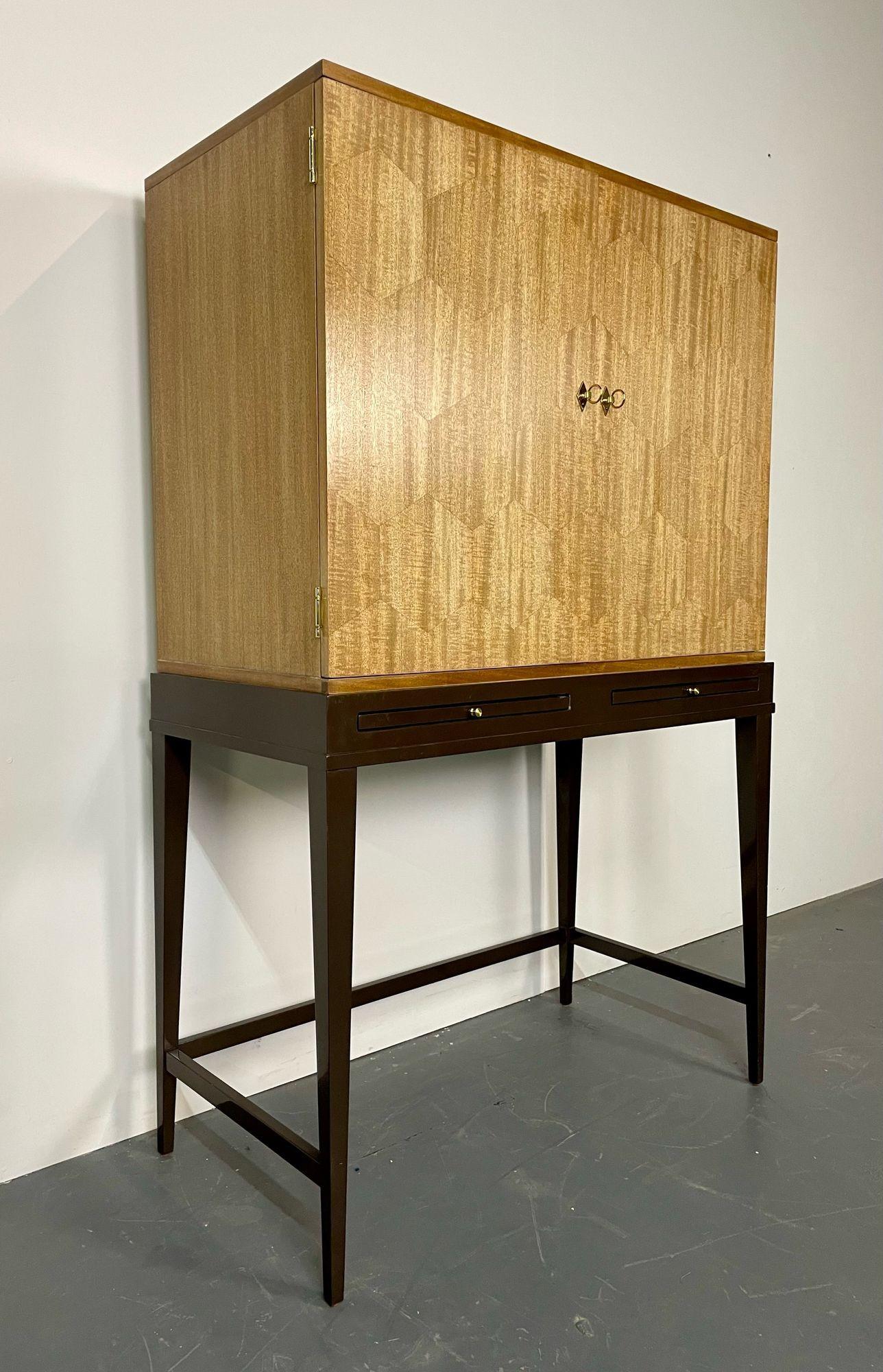 Mid-Century Modern style bar cabinet on stand, lacquer, metal, brass.
A sleek and stunning bar having a high console metal base supporting and a wonderfully constructed double door bar or vitrine cabinet. The lighted interior with mirror back has
