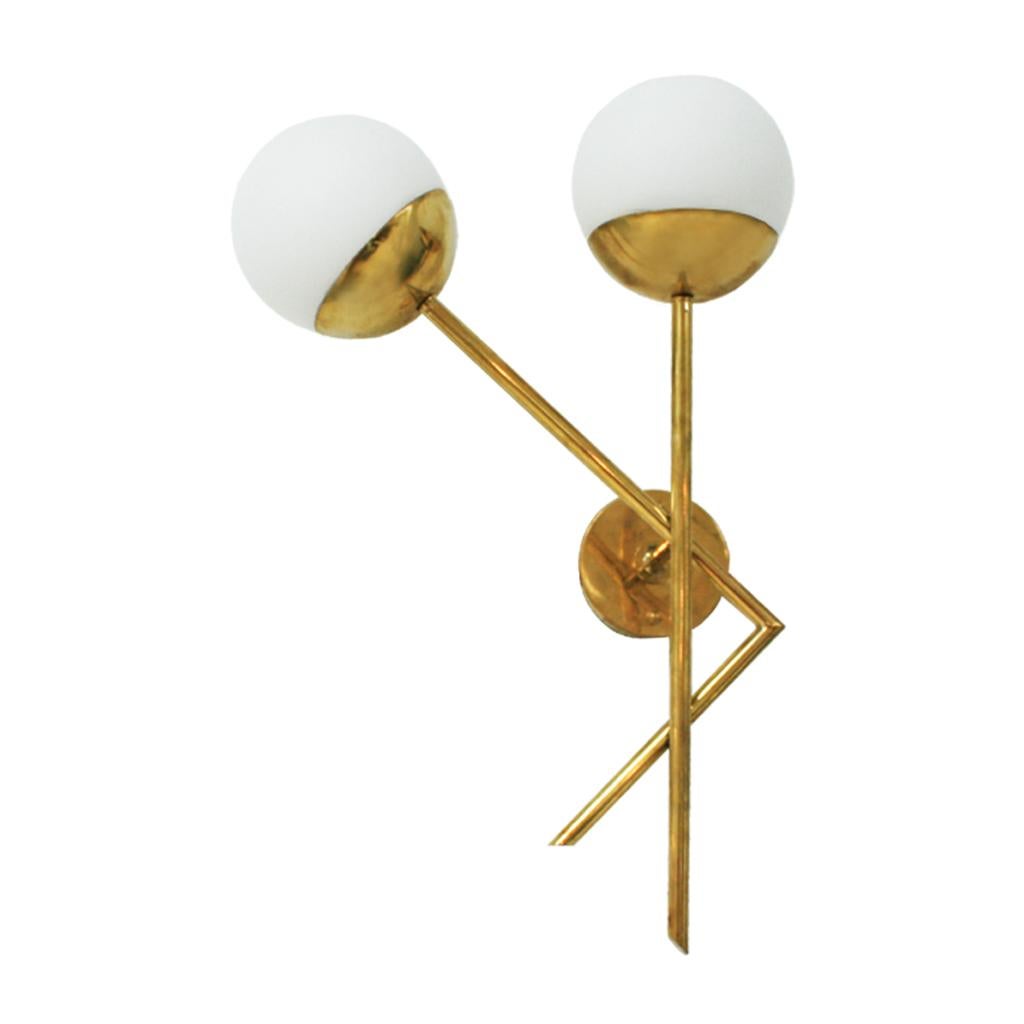 Midcentury style pair of Italian sconces. Composed of two points of light with solid brass structure and white glass spheres.


 