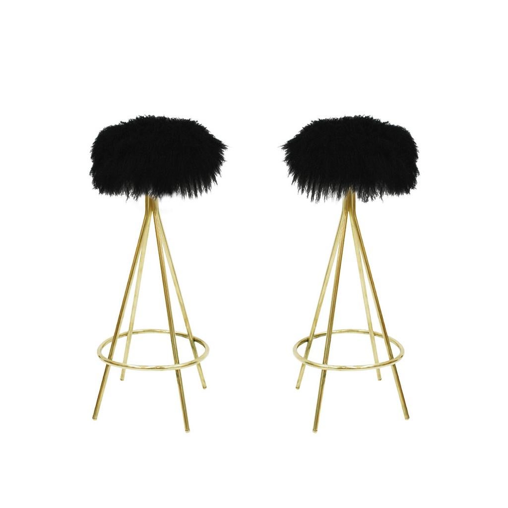 Modern circular Italian bar stool, made of polished brass structure with bottom footrest ring and upholstered in black Mongolian goat fur.