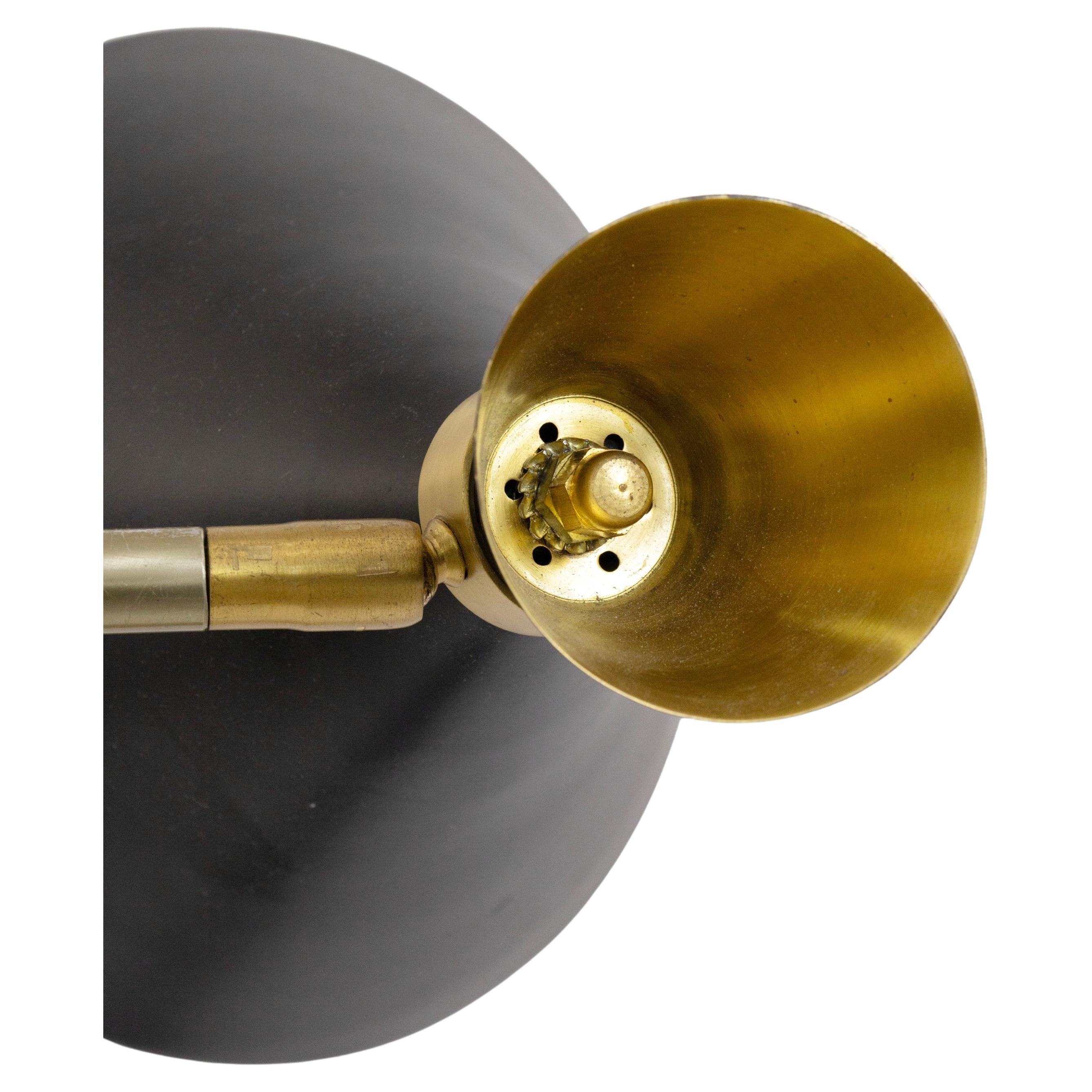 Ce lampadaire saisissant de style moderne du milieu du siècle est doté d'une tige élégante en laiton associée à quatre abat-jour coniques sculpturaux en métal noir, chacun étant fini avec un intérieur en laiton chaud qui rehausse l'éclat. Les