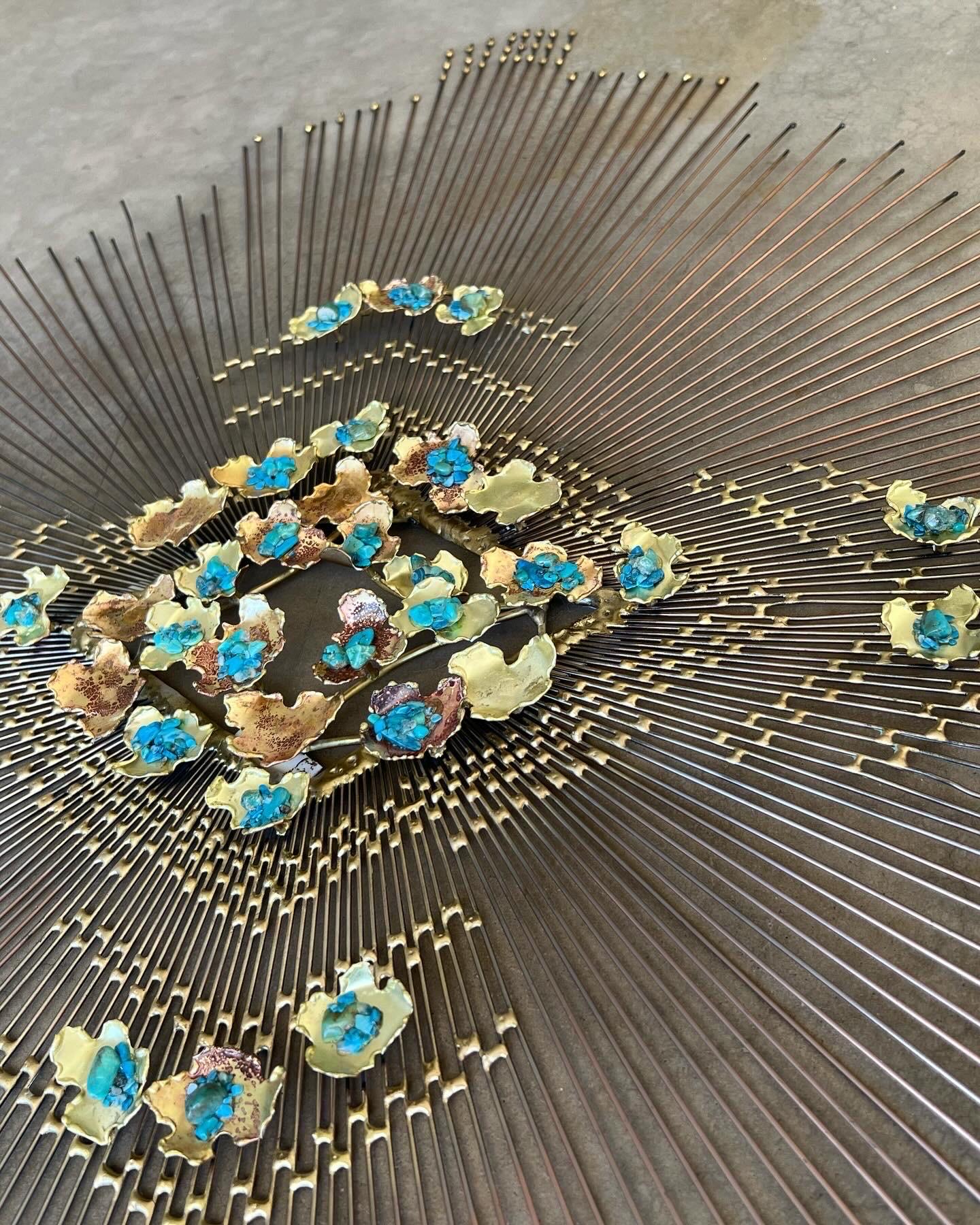 Mid century modern brass starburst wall sculpture with turquoise accents. The age  and maker are unknown, and there is no signature. The style and features are very similar to William and Bruce Friedle pieces around the same time period as C. Jeré