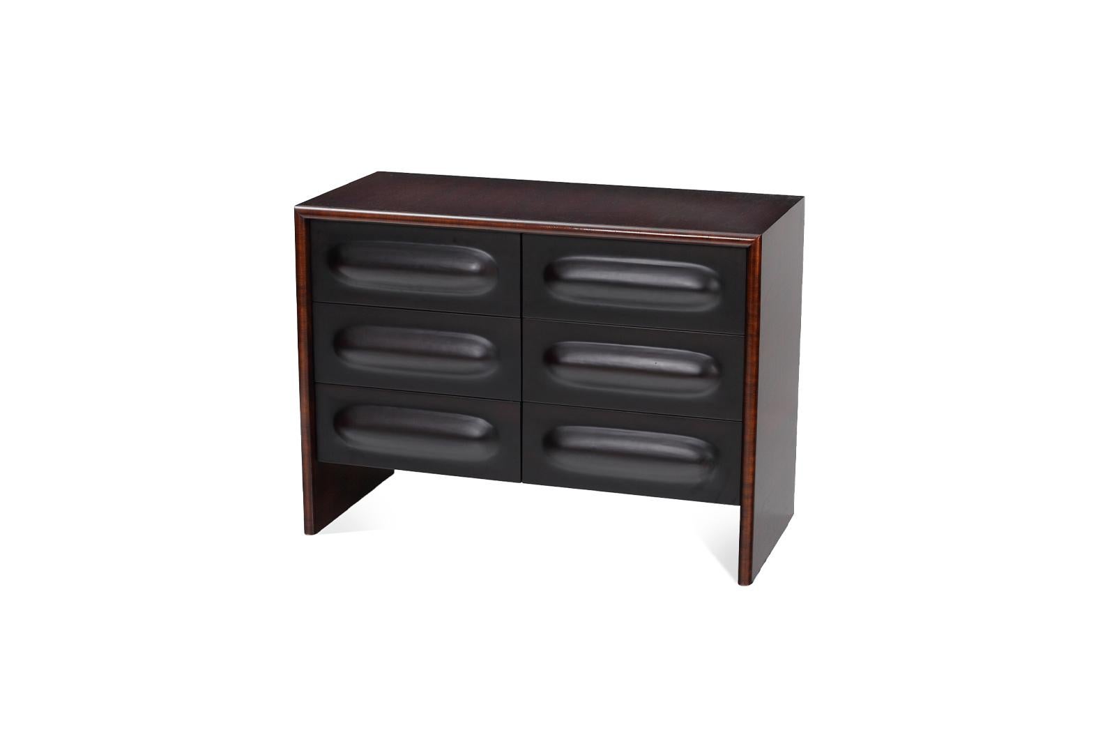 This stylish and contemporary chest of drawers is a beautiful blend of rich wood and minimalist design. It features a sleek, rectilinear silhouette with a deep, dark wood veneer. The most distinctive element is the front, which is composed of six