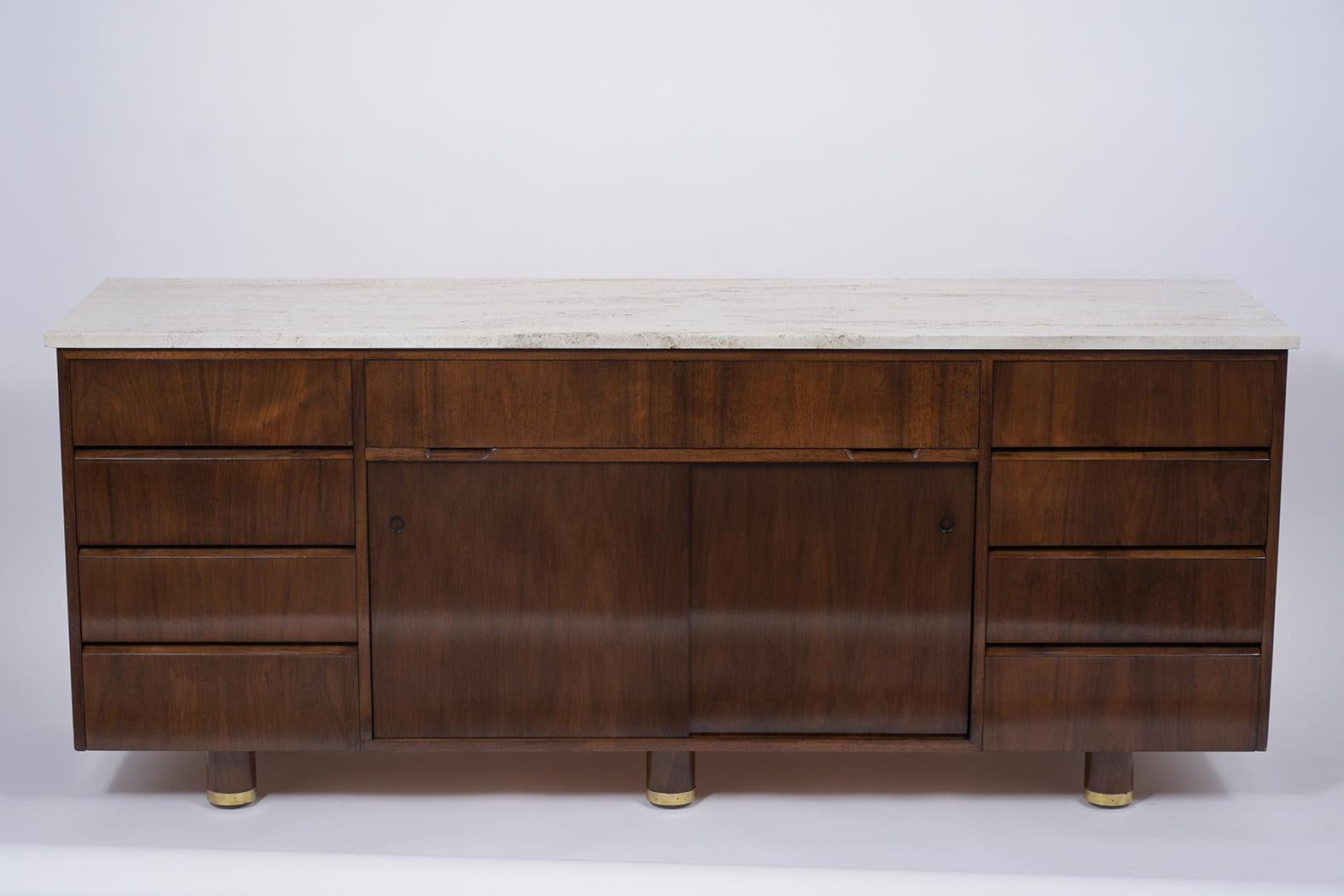 A well crafted midcentury style credenza made from walnut wood and has been completed restored. This fabulous dresser features a soft color travertine marble top in great condition, elegant dark walnut color, and newly lacquered finish. It also