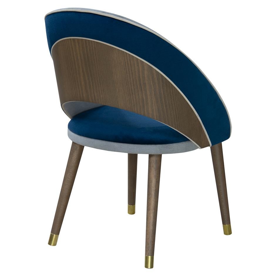 Mid-Century Modern dining chair upholstered in velvet. 
Crafted of solid wood frame stained in variety of colors.
Curved back for greater support and comfort to enjoy long dinners.
Rounded brass metal caps.
Suitable for contract use.
“Minimum order